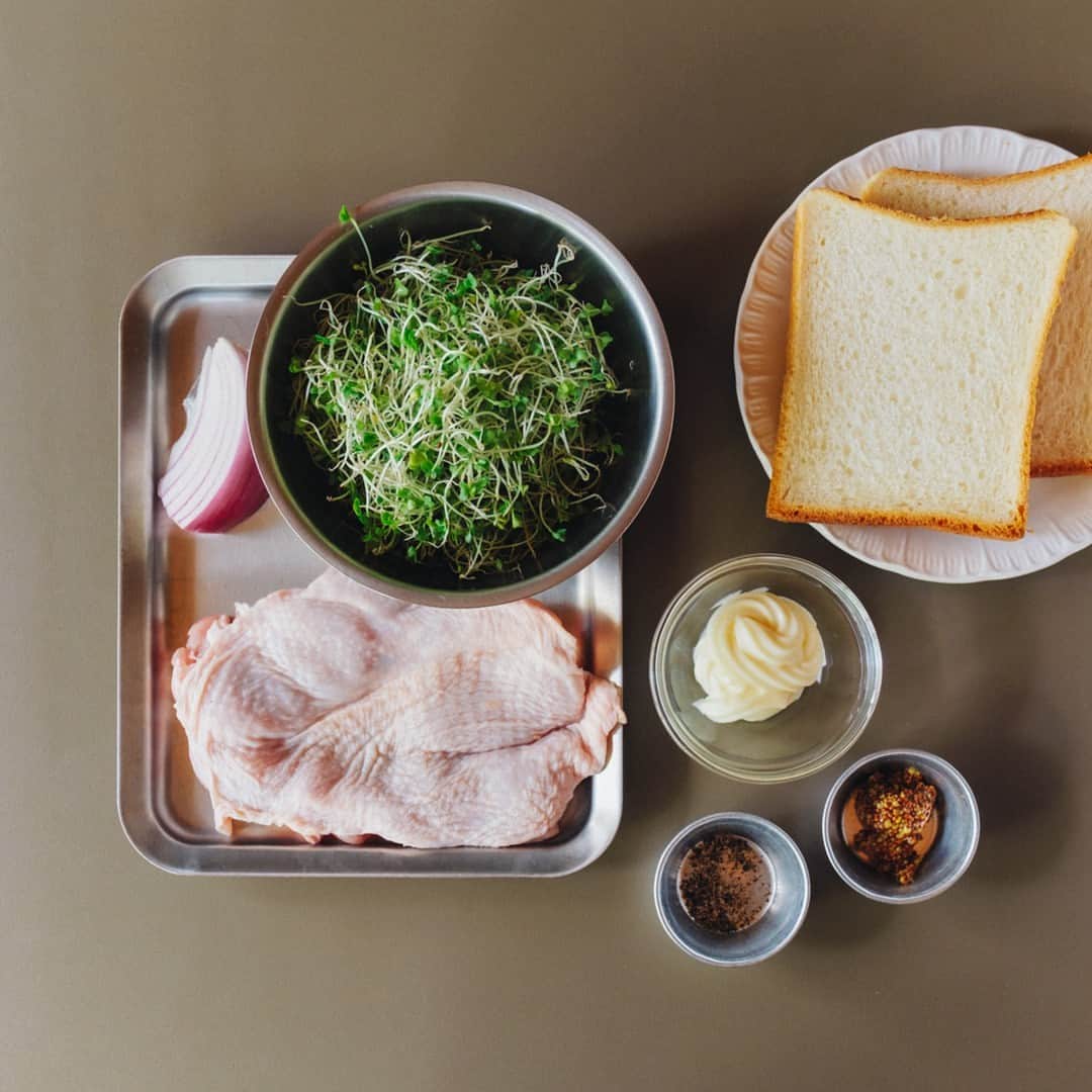 北欧、暮らしの道具店さんのインスタグラム写真 - (北欧、暮らしの道具店Instagram)「【ごきげんサンド】 カリッカリのチキンソテーが主役！ 育ちざかりも大満足な「わんぱくサンドイッチ」 . - - - - - - - - - - - - - - - - -  作って楽しい、目で見て嬉しい サンドイッチのレシピを、 料理家の小堀紀代美（こぼり きよみ）さんに 伺っています。  今回ご紹介するのは、 ジューシーなチキンとたっぷり野菜で ボリューム満点のサンドイッチです。 . - - - - - - - - - - - - - - - - - カリカリに焼くコツは、じっくり待つこと。 チキンソテーが主役の「わんぱくサンド」 - - - - - - - - - - - - - - - - -  【材料（2つ分）】 食パン…2枚（6枚切り） 鶏もも肉…1枚（約200g） ブロッコリースーパースプラウト…1パック分（50g） 紫玉ねぎ…1/6個（30g） マヨネーズ…大さじ2と1/2 粒マスタード…小さじ1と1/2 黒こしょう…適量  ※紫玉ねぎは普通の玉ねぎでも同様にお作りいただけます ※ブロッコリースーパースプラウトがなければ、  キャベツの千切り（120g）で代用できます  【作り方】 ❶チキンソテーを作る。 鶏肉は余分な脂や筋を取り除いておく。 フライパンを中弱火にかけて温め、 オリーブオイル大さじ1（分量外）を入れる。 皮目をぴんと張った鶏肉を入れ、 塩小さじ1/3（分量外）をふったら、 ヘラなどで皮目をぎゅーっと 押し付けるようにして焼く。 鶏から出てきた脂をキッチンペーパーなどで 拭き取りながら、皮目全体が香ばしく 焼けるまで15分間ほど焼き続ける。 皮目全体が香ばしく焼け、 鶏肉の側面の3/4程度まで火が通ったら 裏返して弱火にし、 さらに2〜3分焼いて完成。  ❷玉ねぎは千切りに、 スプラウトは洗ってしっかり水けを切り、 キッチンペーパーでさらに拭う。 マヨネーズ（大さじ1と1/2）と ブラックペッパーを加え、 全体をよく混ぜておく。  ❸食パンは2枚重ねて、 表面に焼き目がつくまでトーストする。 食パンの内側にマヨネーズ（残りの大さじ1） と粒マスタードを塗る。  ❹1を山盛りにのせた上にチキンソテーを のせ、お好みで塩と黒こしょうを軽くふる。 もう1枚の食パンで挟み、 上からぎゅっと押さえる。  ❺大きめにカットしたクッキングシートの 中央にサンドイッチを置く。 シートの上下の端をあわせて、 1cm幅で折りたたんでいく。 左右の端は上から押さえながら三角形に折り、 底面のほうに折り曲げる。 半分にカットしたら完成。 . - - - - - - - - - - - - - - - - - ■ 小堀さん  「鶏肉は分厚くても開いたりせず、 そのまま焼くのが肉汁を逃さないためのポイント。 じっくり、焦らずに、皮目全体が フライパンの底に平らにぴったり くっつくよう焼くのがコツです。  一緒にキノコなどをソテーすると、 それだけでメイン料理としても 召し上がれますよ」 . - - - - - - - - - - - - - - - - - . #kitchen#kitchendesign#kitchenware#food#foodstagram #サンドイッチ#チキンソテー#レシピ#サンドイッチレシピ#お弁当#ランチ#お昼ご飯#夜ご飯#今日のごはん#小堀紀代美 さん#家じかん#料理#キッチン#キッチン雑貨#シンプル#シンプルライフ#シンプルデザイン#暮らしを楽しむ#日々の暮らし#北欧#暮らし#北欧暮らしの道具店」7月16日 7時01分 - hokuoh_kurashi
