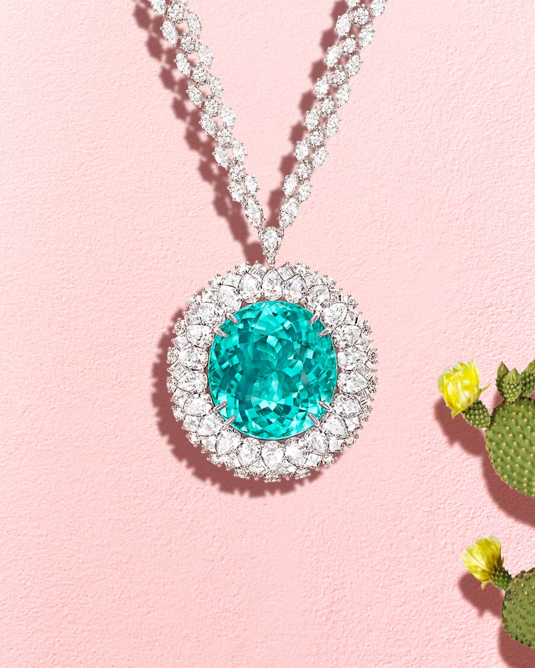 ハリー・ウィンストンのインスタグラム：「Surrounded by a halo of brilliant diamonds, an extraordinarily rare 135.93 carat oval Paraiba tourmaline beautifully glows in the hot summer sun. Discover magnificent jewels by tapping the link in bio. #HarryWinston #WinstonHighJewelry」