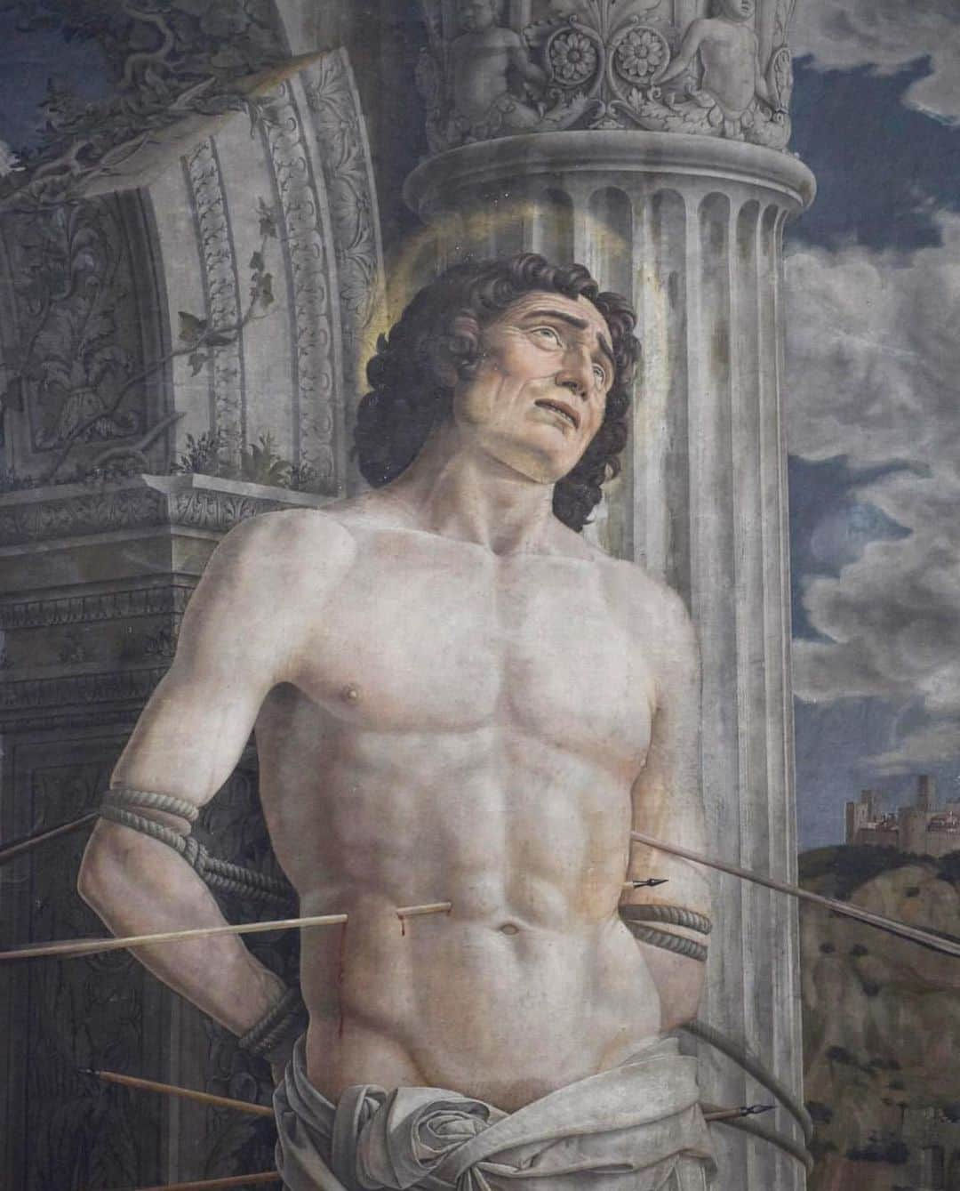 ルーブル美術館のインスタグラム：「#LouvreAnecdotes 🇫🇷 Savez-vous que le saint Sébastien de Mantegna se trouvait jusqu’au début du 20e siècle à Aigueperse, en Auvergne ?   - ✍️ La dévotion à saint Sébastien, protecteur contre la peste, était très forte au 15e siècle. L’iconographie traditionnelle est ici renouvelée par l’introduction de nombreuses références antiques. Mantegna s’est livré avec passion à la redécouverte de l’Antiquité, encouragé par son maître Squarcione et par ses fréquentations dans les milieux humanistes padouans.   - 🎁 Ce tableau fut probablement offert à l’occasion du mariage, en 1481, de la fille du protecteur de Mantegna, Federico Gonzaga, marquis de Mantoue, avec Gilbert de Bourbon, comte de Montpensier, alors au cœur d’une cour princière puissante à Aigueperse. Cet élément permet d’expliquer la présence de l’œuvre en Auvergne dès la fin du 15e siècle.   ∴ 🌍 Did you know that, until the early 20th century, Mantegna's Saint Sebastian could be found at Aigueperse in the Auvergne region of France?   - ✍️ Devotion to Saint Sebastian, protector against the plague, was very strong in the 15th century. Here, traditional iconography is renewed by the introduction of numerous antique references. Mantegna was passionately committed to the rediscovery of Antiquity, encouraged by his master Squarcione and his acquaintances in Paduan humanist circles.    - 🎁 This painting was probably offered on the occasion of the marriage, in 1481, of the daughter of Mantegna's patron Federico Gonzaga, Marquis of Mantua, to Gilbert de Bourbon, Count of Montpensier, then at the heart of a powerful princely court in Aigueperse. This explains the work's presence in Auvergne as early as the end of the 15th century.  - 📷 © Musée du Louvre / Nicolas Bousser  . . . #Louvre #MuseeDuLouvre」