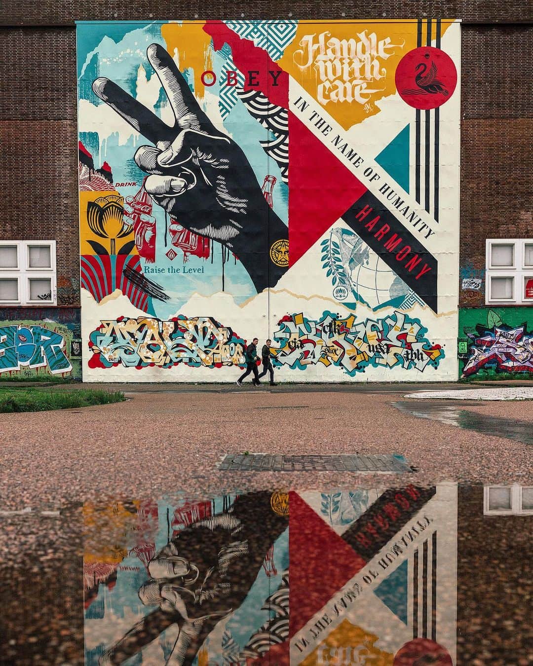 Shepard Faireyさんのインスタグラム写真 - (Shepard FaireyInstagram)「Reflecting on my mural at the Straat Museum in Amsterdam, I feel very lucky that though it rains a lot here, the weather allowed us to finish the mural on time despite some intense winds. The Straat is a huge old factory where they built ships so the surface I painted is a set of metal doors 45 feet high formerly used to get the ship parts out of the building. The doors are a smooth surface and provided an ideal canvas for the “Raise the Level” mural. The mural is based on one of my art pieces focused on peace and harmony which is included in my exhibition at Straat. I also added some additional text and imagery to fit the composition of the doors. I have been friends with Amsterdam local and calligraffiti pioneer Niels Shoe Meulman for over 10 years and I asked him if he would collaborate on part of the mural. He generously added the “Handle with Care” in his unique style as well as a wild style piece down below. He also brought his friend, and O.G. graff writer Yalt to do the piece on the lower left. I’m very happy about the street art and graffiti hybrid of the entire piece because I believe the two genres are driven by the same spirit. Also, the Straat Museum celebrates and showcases both movements. I’m very grateful to my crew of Dan Flores, Rob Zagula, and Jon Furlong for their hard work helping with the mural. Thanks to @jonathanfurlong also for the great photos. A huge thanks to the Straat crew for hosting and being incredibly pro about EVERYTHING. Check out my show “Raise the Level” at Straat if you are in Amsterdam! -Shepard」8月12日 19時44分 - obeygiant