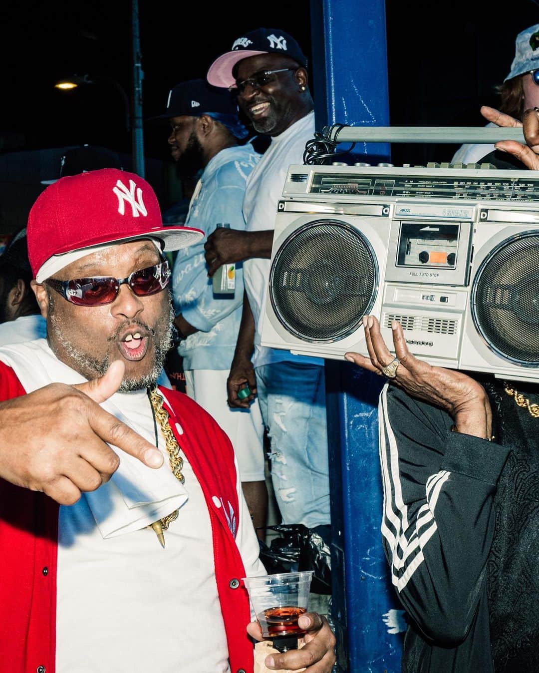 New York Times Fashionさんのインスタグラム写真 - (New York Times FashionInstagram)「The start of hip-hop dates to Aug. 11, 1973, when DJ Kool Herc created continuous break-beats by working two turntables during a party in a rec room at 1520 Sedgwick Ave in the Bronx. On Friday night, exactly 50 years later, a concert was held at Yankee Stadium — roughly a mile and a half from hip-hop’s birthplace — to honor the occasion, featuring Run-DMC, Slick Rick, Ice Cube, Snoop Dogg, Lil’ Kim and Nas. DJ Kool Herc, 68, also appeared onstage to accept an award.  Before the show, which was billed as “Hip Hop 50 Live,” the scene outside the stadium was heavy with fans of the sounds from the ’70s, ’80s and ’90s. Middle-aged couples on date nights arrived wearing matching Adidas track suits. A man strolled the promenade carrying a boombox and wearing a Kangol hat. Hawkers sold pins with pictures of Biz Markie and The Notorious B.I.G.  In interviews with The New York Times, attendees reflected on hip-hop’s 50th. Some recalled witnessing the park jams and parties that defined the genre’s beginnings. Tap the link in our bio to read more reflections on hip-hop and to see more looks from outside the show. Photos by @poupayphoto」8月15日 1時42分 - nytstyle