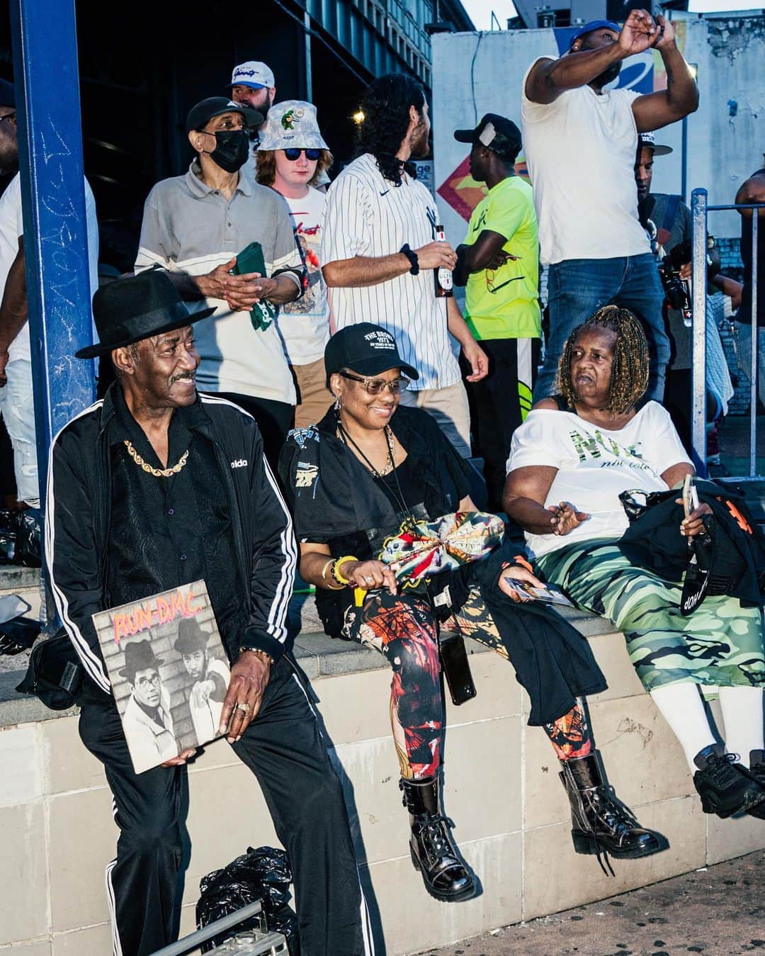New York Times Fashionさんのインスタグラム写真 - (New York Times FashionInstagram)「The start of hip-hop dates to Aug. 11, 1973, when DJ Kool Herc created continuous break-beats by working two turntables during a party in a rec room at 1520 Sedgwick Ave in the Bronx. On Friday night, exactly 50 years later, a concert was held at Yankee Stadium — roughly a mile and a half from hip-hop’s birthplace — to honor the occasion, featuring Run-DMC, Slick Rick, Ice Cube, Snoop Dogg, Lil’ Kim and Nas. DJ Kool Herc, 68, also appeared onstage to accept an award.  Before the show, which was billed as “Hip Hop 50 Live,” the scene outside the stadium was heavy with fans of the sounds from the ’70s, ’80s and ’90s. Middle-aged couples on date nights arrived wearing matching Adidas track suits. A man strolled the promenade carrying a boombox and wearing a Kangol hat. Hawkers sold pins with pictures of Biz Markie and The Notorious B.I.G.  In interviews with The New York Times, attendees reflected on hip-hop’s 50th. Some recalled witnessing the park jams and parties that defined the genre’s beginnings. Tap the link in our bio to read more reflections on hip-hop and to see more looks from outside the show. Photos by @poupayphoto」8月15日 1時42分 - nytstyle