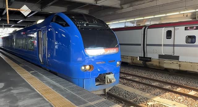 高山沙織のインスタグラム：「【最長片道切符の振り返り旅♯9】こんにちはアンドロイドのお姉さんです。私はただいま秋田駅前に来ております。 今日も今日とて移動していきます。  本日最初に乗る列車は10時35分発 特急いなほ号 いなほ号はグリーン車の座席が在来線特急の 中でも特に広々していて、素晴らしいと聞いていたのでグリーン車で行こうと思ったのですが、人気で隣に人がいる通路側しか開いていませんでした。  通路側だと景色が見えないので普通に自由席で行くことに。  自由席はまあまあ空いていました。 今日のルートは秋田駅から羽越本線を通り日本海側をぐっと南下していくルート。 途中山形県を通って新潟の坂町駅まで約3時間の乗車です。  ここで悲報！！なんとトイレが故障中。 水が流れない状態になっていて、備え付けのペットボトルの水で自分で流してとのこと...。  私は我慢することにしました。 車内では朝ごはんに買っておいた秋田名物アベックトーストを食べます。名物ですが見た目はただの食パンに見えます。肝心な味はというチョコとピーナッツと食パンの味です。  村上駅には電気の直流と交流が切り替わるポイント。 いわゆるデッドセクションがありましてそこを通る時だけ電気が供給されない関係で車内の照明が落ちるのです。夜だっ たら真っ暗になるので分かりやすいのですが、外が明るいので注意して見ておかないと 電気が落ちたことに気づかなさそう。  いなほ号に乗車してから約3時間ようやく目的地 の坂町駅に到着しました。ここから 米坂線に乗り換え米沢駅を目指すのですがいったん改札をでます。 緊急でトイレに駆け込みました。  ただ、ホームには戻りません。 今から乗る米坂線は去年の豪雨の影響により一部不通になっており、その区間を代行バスが担っているのです。 駅前にはすでに代行バスが待っていました もちろん最長片道切符で乗車できます。  バスは坂町駅から県境を通り山形県の今泉という まで走っていきます。 米沢駅まで行くにはまた列車を乗り継いで いくのです。 代行バスは米坂線に並行する国道113号 線を進んでいきます 終点今泉まではなんと2時間10分 なかなか遠いですね ぼーっと車窓を眺めているとまるで水墨 画家と思うほど美しい景色が流れてきますそして県境を通過し再び山形県へ。  気づけば代行バスの終点今泉駅に到着です 。 ここから米沢駅行きの普通列車に乗り込んでいきます。 と、ここでまさかのトイレ使用禁止。今日は本当にトイレ運がないですね。  乗車時間は約30分だったので漏らす心配もなく安全に米沢駅に到着しました。  米沢といえば全国的にも有名なのが米沢牛。 駅前にも米沢牛が食べられるレストランが 立ち並んでいますが、次に乗りたい新幹線がちょうど1時間後なので焼肉は無理かもしれないなと。  ということで駅ナカの立ち食いそば処に 行きます 。ここで米沢牛の牛丼が食べられるのですが、残念なことに牛丼売り切れ 。仕方ないので牛肉そばを食べます  1杯980円というお値段を見ていただければわかると思うのですが、そばはそばでも米沢牛入りそば   これは美味しかったしかも10分で食べ終わりました   次は米沢から奥羽本線を通りぐっと北上していきます。せっかく新潟まできたのにまた北上...。え、なんでってなりますよね私も なりました。でもそれが最長片道切符なの です。 次に乗るのは山形新幹線つばさ 1時間 22分で終点の新庄駅に到着しました。そして次は奥羽本線の普通列車に乗車します。約1時間乗車しまして秋田県の 十文字駅で降りました。 十文字駅初めて来ました。 あの釣りキチ三平の故郷なんだそう  この日は十文字にあるゲストハウスに宿泊します。 南下したかとおもえば北上したり。新幹線に乗ったかと思えば普通列車に乗り換えたりと今までで最長片道切符のヤバさを1番感じたそんな日でした。」