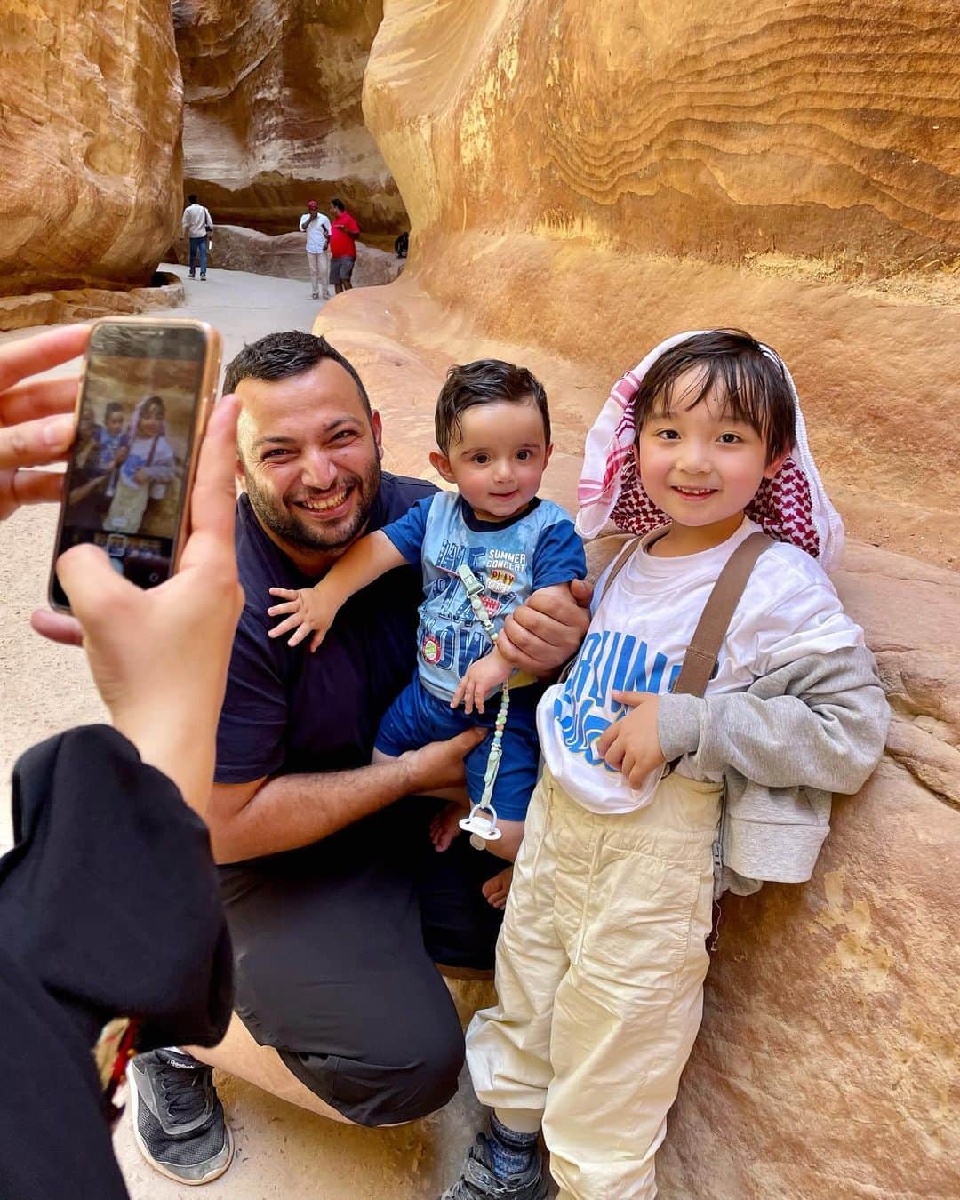 石塚錬さんのインスタグラム写真 - (石塚錬Instagram)「WORLD TOUR DAY11 〜ヨルダン🇯🇴編〜 👦💬「I'm in ペトラ❣️ 中東のヨルダンにきました🇯🇴✈️ 遺跡の神殿をみたときは思わずワッて声がでました🥺 気温は40℃以上あってさすがにラクダさんも暑そうでした🐪 ターバンを巻いて色んな人と写真を撮りました🤳👳(これも帽子のお土産です🧢)」 . （👨パパ通信📨）ドイツ経由で7時間、ヨルダンに到着しました✈️🇯🇴。ペトラはインディジョーンズの舞台になった遺跡で、岩壁を削って大都市を作ったそうです(世界遺産)。レンはターバン効果か沢山の人に声をかけられていました🤳特にほっぺたが大人気でした笑 . 👦💬 「I'm in Petra❣️ I'm in Jordan in the Middle East🇯🇴✈️ I couldn't help but gasp when I saw the temple🥺. The temperature was over 40 degrees Celsius and even the camels looked hot🐪. I took pictures with many people wearing turbans🤳👳(This is also a souvenir of my hat. It's also a souvenir of the hat 🧢)」 . (👨Papa News 📨) It is the site where Indiana Jones was set (World Heritage Site)🇯🇴. They built a big city by carving out a rock wall. It took about 7 hours to get to Jordan via Germany. Ren was approached by many people, probably due to the turban effect🤳. His cheeks were especially popular lol. . #男旅 #世界一周 #旅 #ヨルダン  #旅行 #ペトラ遺跡 #砂漠 #中東 #ラクダ #ターバン #インディジョーンズ #世界遺産 #Mantrip #aroundtheworldtrip #trip #middleeast #Jordan #petra #camel #worldhelitage #여행 #남자여행 #การเดินทาง #ทริปผู้ชาย #Perjalanan #石塚錬 #成長日記 #ishizukaren #renishizuka #이시즈카렌」8月15日 18時59分 - ishizuka_ren