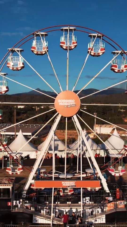 Sorriso Marotoのインスタグラム：「Minas Gerais, nossos portões abriram às 17h e foi uma energia SURREAL!! 😍 Tá tendo karaokê as antigas? Sim! Teve o quadro de recados pra você deixar sua msg pro @sorrisomaroto? Claro! Roda gigante e tobogã pra sentir essa experiência do alto? Siiim! Tudo incrível! 🫶🏽 Daqui a pouco tem @sorrisoasantigas!  Preparados, turma? 🧡」