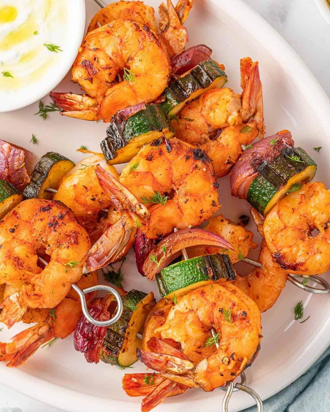 Easy Recipesのインスタグラム：「Marinated Oven Shrimp Skewers are zesty, flavorful and make the perfect weeknight dinner. This grilled shrimp recipe is paired with onions, zucchini, and a bright Mediterranean marinade with lemon garlic and oregano. These marinated shrimp skewers can be grilled indoors or outdoors and enjoyed year-round.  Full recipe link in my bio @cookinwithmima  https://www.cookinwithmima.com/grilled-oven-shrimp-skewers/」