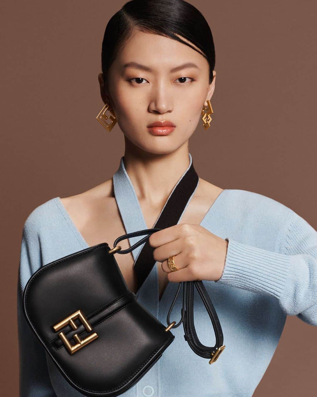 Fendiのインスタグラム：「New in, the #FendiCmon, inspired by the pure lines of #FendiFW23 and available in three different sizes, each with unique characteristics.   Artistic Director of Couture and Womenswear: @mrkimjones​ Artistic Director of Accessories and Menswear: @silviaventurinifendi ​ Artistic Director of Jewellery: @delfinadelettrez​  Creative Direction: @ronnie.cooke.newhouse @karlbolander  Photography: @craigmcdeanstudio  Styling: @themelanieward Hair: @anthonyturnerhair Makeup: @peterphilipsmakeup  Casting: @shelleydurkancasting Set Design: @alexanderbockstudio  Model: @yilan_hua」