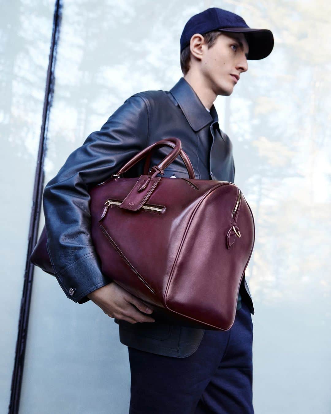ベルルッティのインスタグラム：「- THE SILHOUETTE: FALL 2023 BY #BERLUTI -   Leather on leather: a supple calf jacket is the ideal outerwear piece for everyday use as Summer starts to fade. Paired with the Jour Off bag in the new seasonal Grape patina, it makes for a bold look for a city adventure or an impromptu escape.   Coming soon online and in-store.   Styling by @virginiebenarroch  Photography by @anthonyseklaoui   #BerlutiFall2023」