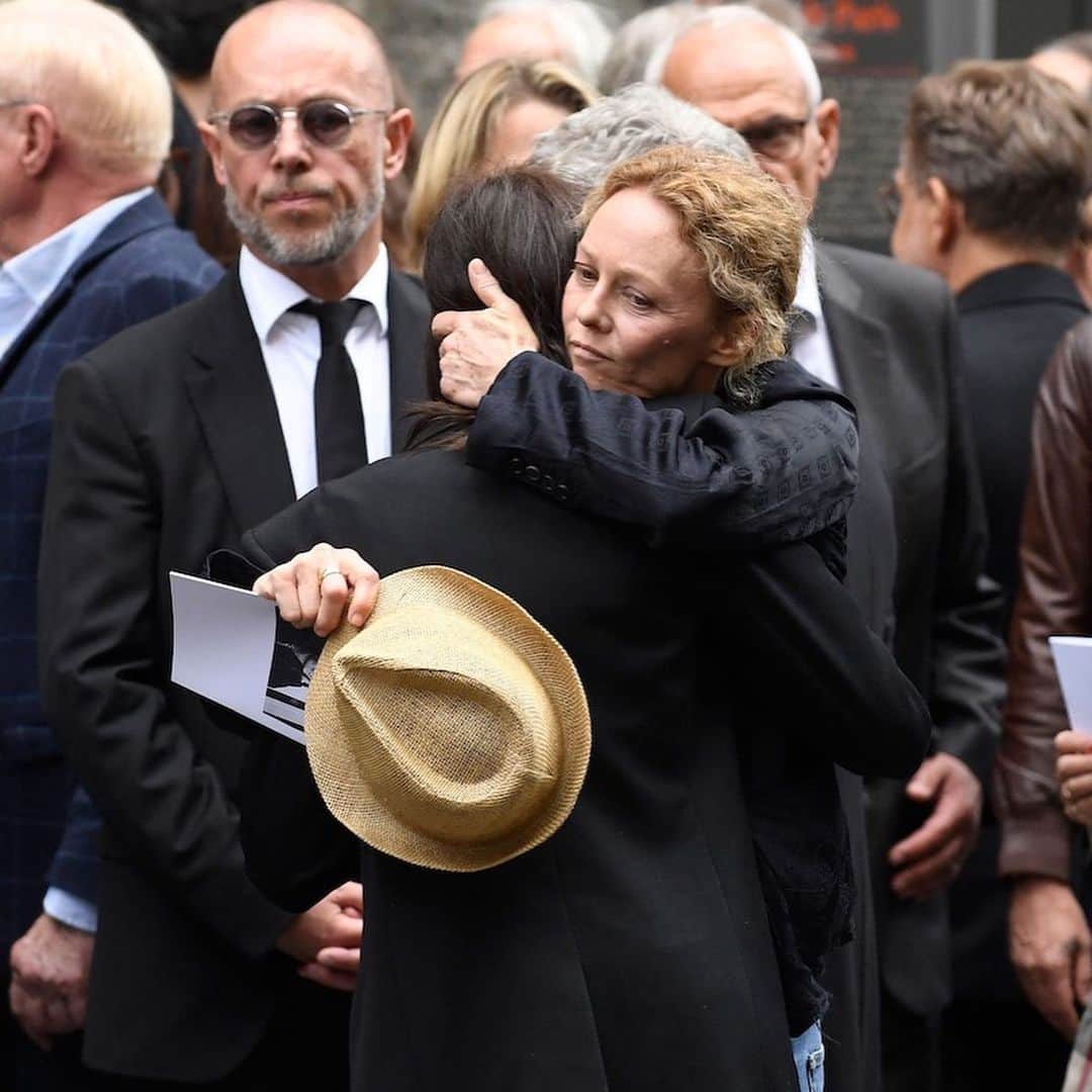 WWDジャパンさんのインスタグラム写真 - (WWDジャパンInstagram)「ニュース：故ジェーン・バーキンの葬儀、娘のシャルロット・ゲンズブールやルー・ドワイヨンらが参列  7月16日に76歳で死去したイギリスの俳優でシンガーのジェーン・バーキン（Jane Birkin）の葬儀が24日、パリのサン・ロック教会で行われた。バーキンの次女シャルロット・ゲンズブール（Charlotte Gainsbourg）と三女ルー・ドワイヨン（Lou Doillon）をはじめとする親族のほか、ブリジット・マクロン（Brigitte Macron）仏大統領夫人、リマ・アブドゥル・マラク（Rima Abdul Malak）仏文化大臣、カトリーヌ・ドヌーヴ（Catherine Deneuve）とその娘であるキアラ・マストロヤンニ（Chiara Mastroianni）、ヴァネッサ・パラディ（Vanessa Paradis）、キャロル・ブーケ（Carole Bouquet）、シャーロット・ランプリング（Charlotte Rampling）、アンソニー・ヴァカレロ（Anthony Vaccarello）「サンローラン（SAINT LAURENT）」クリエイティブ・ディレクターらが参列し、故人を偲んだ。  教会に棺を運び込む際には、男性たちと共にシャルロットとルーも棺を担いだ。葬儀で、シャルロットは「（ジェーンが）いなくなったことで、皆さんの魂が苦しんでいることが伝わってきます。私たちの中には、彼女が残していった空洞があります。彼女は私の母であり、私たちの母でした」と語った。ルーは母との思い出を話した後、「あなたがくれた全ての冒険に、そしてあなたが平凡で、中庸で、従順な人ではなかったことに感謝します。（あなたのいない）明日からのこの世界は、とても平穏で整然としているだろうことを思い、すでに動揺しています」と述べた。  葬儀は家族と関係者のみで執り行われたが、その様子は教会の外に設置されたスクリーンに映し出されており、周辺に集まった多くのファンも故人を悼んだ。葬儀が終わり、教会から棺を運び出す場面では、1991年に亡くなったパートナーのセルジュ・ゲンズブール（Serge Gainsbourg）が作詞・作曲し、バーキンが歌う「ラ・ジャヴァネーズ（La Javanaise）」が流されたという。バーキンの棺はパリのモンパルナス墓地に移され、ゲンズブールと2013年に亡くなった長女のケイト・バリー（Kate Barry）の隣に埋葬される。  詳細は @wwd_jp プロフィールのリンクから  JULIEN DE ROSA/AFP GETTY IMAGES ©︎FAIRCHILD PUBLISHING, LLC  #janebirkin#birkin#ジェーンバーキン#バーキン#葬儀#charlottegainsbourg#loudoillon#vanessaparadis#catherinedeneuve」7月25日 16時06分 - wwd_jp