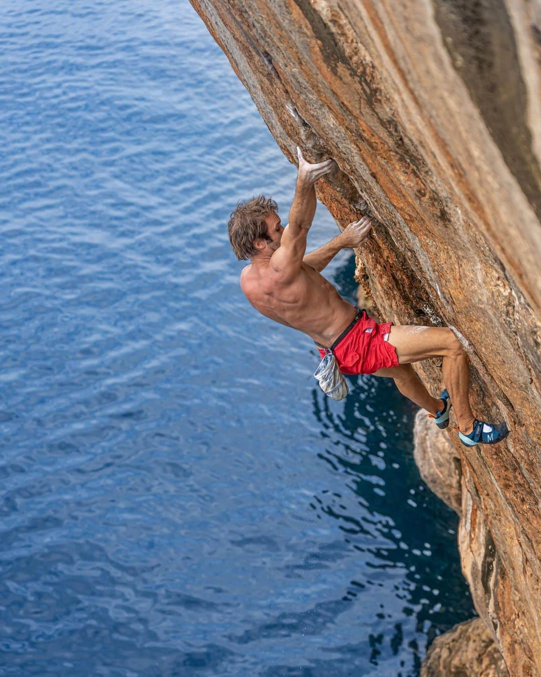 クリス・シャーマのインスタグラム：「Psicobloc summer 🧗 💦  “The feeling of being 60 feet above the water at the lip of a cave, and just dangling by your fingertips, chalking up, and getting ready to go for a crux move,” says @chris_sharma. “It’s so extreme and wild and spectacular, and yet controlled and safe, too.”  📷: @giancolafoto  #climbing #deepwatersolo #mallorca」