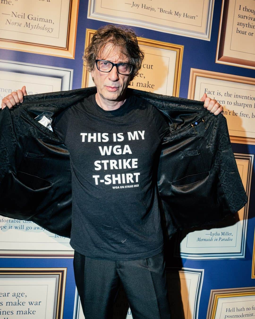 のインスタグラム：「Across New York and Los Angeles, T-shirts advertising support for creative workers’ labor unions are nearly everywhere you look. On the subway, in line at the grocery store and at the coffee shop, creative types and their allies in both cities are eager to wear support for the strikes on their literal sleeves.  SAG-AFTRA, the actors’ union, decided on its own strike last week. The Writers Guild of America, the labor union that represents screenwriters, went on strike in early May. As the demonstrations head into a 13th week, a pressing need has arisen: clean T-shirts.  Enter WGAStrikeShirts.com. The online shop, run by a screenwriter and 12-year member of the Writers Guild named Tripper Clancy, sells WGA. and SAG-AFTRA strike paraphernalia including hats, tank tops and a tomato-red pencils down T-shirt of Neil Gaiman fame. Since its creation on May 5, the website has sold more than $100,000 worth of merchandise, according to Clancy, with 100 percent of the net proceeds going to the Entertainment Community Fund, a charity that supports performers, artists and entertainment industry workers.  Its best sellers include a plain white shirt with black lettering that reads, “Pay the Writers and the Actors and the Crew and the Teamsters and Anyone Else Who Makes You All the Money,” and a black T-shirt with a red “fist of solidarity” naming unions involved in the strike.  Personal style has long been a way to express political or social affiliation, but what one wears to the picket line is especially important: By wearing matching union gear, workers become a visual representation of the solidarity they’re trying to reflect.  Read more about these messages in the merch at the link in our bio. Photos by @poupayphoto, @markabramsonphoto and WGAStrikeShirts.com」