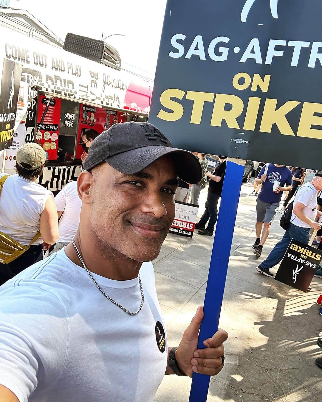 ボリス・コジョーのインスタグラム：「On the picket line with my TV family in front of the coffee truck donated by our incredible fans. Thank you all. We love you guys. ❤️  Just to clarify; this is not a matter of spoiled celebs demanding more riches. Most SAG members earn just under $40K per year and 85% of us don’t even make the required $26K per year to qualify for health insurance. The Tom’s, Chris’ and Jennifer’s you know from your favorite blockbusters and magazine covers make up less than half a percent of our union.   This fight is about getting a fair share from streaming revenues and film/TV content sales in order to be able to earn a livable wage with health insurance for our kids. It’s about receiving basic protection from AI innovation that could potentially threaten our very livelihoods.   And let’s not forget the devastating impact the strike has had on all the hundreds of thousands of other workers who help us bring your favorite movies and TV shows to the screen. Catering, electricians, wardrobe, hair & makeup, craft service, lighting technicians, props department, camera crew, transportation, carpenters, painters, office staff, health & safety etc.   I have been a member of SAG for 25 years and I’m proud to be out here with my SAG & WGA brothers and sisters walking and shouting for what’s right.  Auf gehts! ❤️🙏🏾✊🏾」