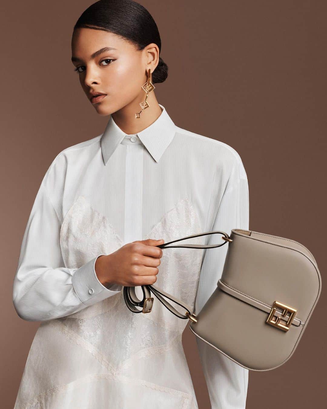 Fendiのインスタグラム：「A pure approach characterises #FendiFW23 accessories, from the new #FendiCmon bag to fashion jewellery.   "I wanted to explore the purity of the FF, locking it on the ear. Like the collection it goes to the very essence of Fendi." – Delfina Delettrez Fendi   Artistic Director of Couture and Womenswear: @mrkimjones​ Artistic Director of Accessories and Menswear: @silviaventurinifendi ​ Artistic Director of Jewellery: @delfinadelettrez​  Creative Direction: @ronnie.cooke.newhouse @karlbolander  Photography: @craigmcdeanstudio  Styling: @themelanieward Hair: @anthonyturnerhair Makeup: @peterphilipsmakeup  Casting: @shelleydurkancasting Set Design: @alexanderbockstudio  Model: @farah_nieuwburg」