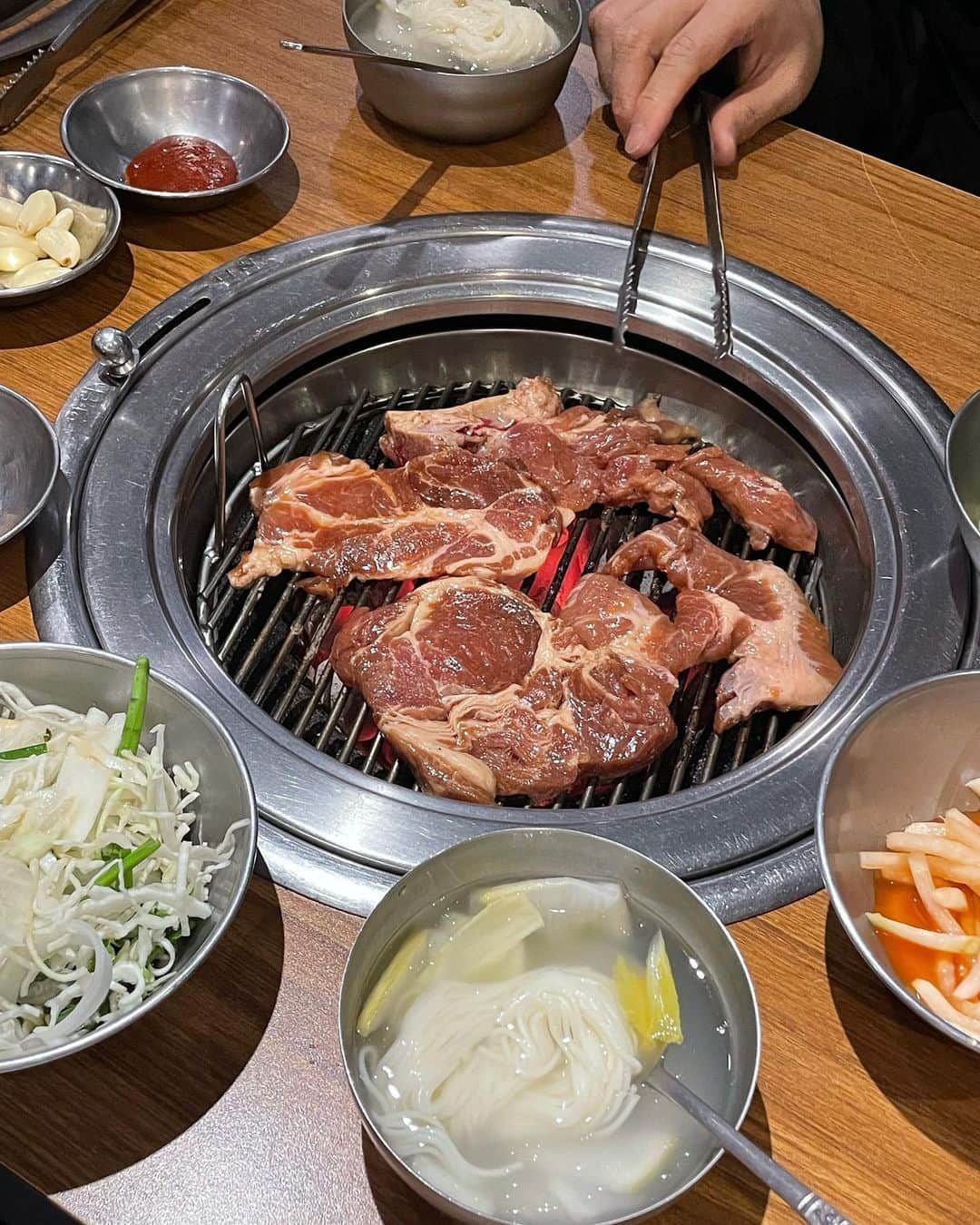 高井香子のインスタグラム：「【激うまテジカルビ🐖】  #원조조박집본관 #원조조박집   あまり期待せず入ったんだけど（失礼） このお店があるエリア、テジカルビ天国だったので入る店悩んだけどここにして大正解🥹  何も言ってないけど、テジカルビっしょ？ みたいなテンションでおばさまがどんどん準備してくれて おじさんが炭火を持ってきてくれて あれよあれよとテーブル一杯に。  大根水キムチそうめんが、夏場に間違いなくぴったり！ 本当に美味しくて、これが付いてくるなんて幸せすぎる。  みんながテンジャンチゲ頼んでるので私も頼んだけど100円なの。笑  お肉以外のサイドメニューの値段バグってますこちら。笑  肝心のお肉が、味染み染みで柔らかくてキャベツとかが入ったソースと一緒に食べたら止まらない...  何食べても美味しいし、また絶対食べに行きたいくらい美味しかった🫣♡  野菜と一緒に食べるから脂っぽさもなくて、最高！  住所こちら。  서울 마포구 토정로37길 3  #1日1こうこりあさんぽ  #韓国旅行 #韓国料理屋  #韓国グルメ」