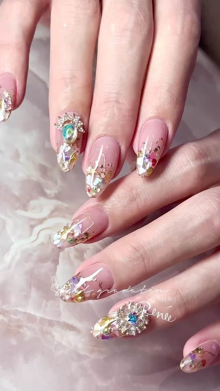 埜藤理恵のインスタグラム：「シェルグラデーション✨ このパーツ可愛くない？♡ どう使うか悩んだけどこのデザインには オーロラストーンを組み合わせるのが一番可愛かった☺️🤍 ポイントはゴールドラインの ふにょんって線が 余白をバランスよくまとめてくれてて好き♡ □ Rie Nofujiプロデュース @tree01official エプロン 好評発売中  □ Renée professional brush シリーズ ＊オーバル ＊トップフレンチ ＊スマートフラット Renée web shop 全国ネイルディーラーにて発売中 プロフィールURLより飛べます  □ 店舗詳細 ⇩ 大阪府大阪市北区堂山町1-2 R&Eビル3階 am10:00〜pm20:00 JR大阪駅から徒歩7分 阪急梅田駅から徒歩7分 御堂筋梅田駅から徒歩7分  ご予約は サロンの公式LINEより受け付けております。 @rrieenee プロフィールURLより LINE飛べます。 LINEにて行き方動画も配信しておりますので ご参考くださいませ」