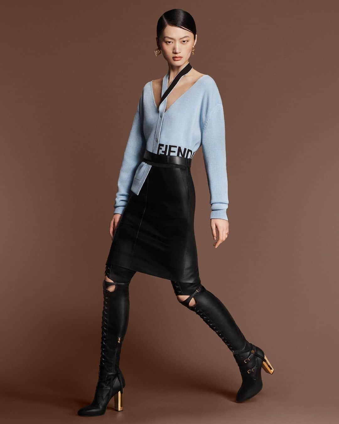 Fendiのインスタグラム：「"There’s a little nod to punk but moved on towards something chic." – Kim Jones  On the #FendiFW23 runway, a slashed cardigan was paired with a leather skirt and over-the-knee boots.  The Delfina boot is now available for pre-order at Fendi.com.  Artistic Director of Couture and Womenswear: @mrkimjones​ Artistic Director of Accessories and Menswear: @silviaventurinifendi ​ Artistic Director of Jewellery: @delfinadelettrez​  Creative Direction: @ronnie.cooke.newhouse @karlbolander  Photography: @craigmcdeanstudio  Styling: @themelanieward Hair: @anthonyturnerhair Makeup: @peterphilipsmakeup  Casting: @shelleydurkancasting Set Design: @alexanderbockstudio  Model: @yilan_hua」