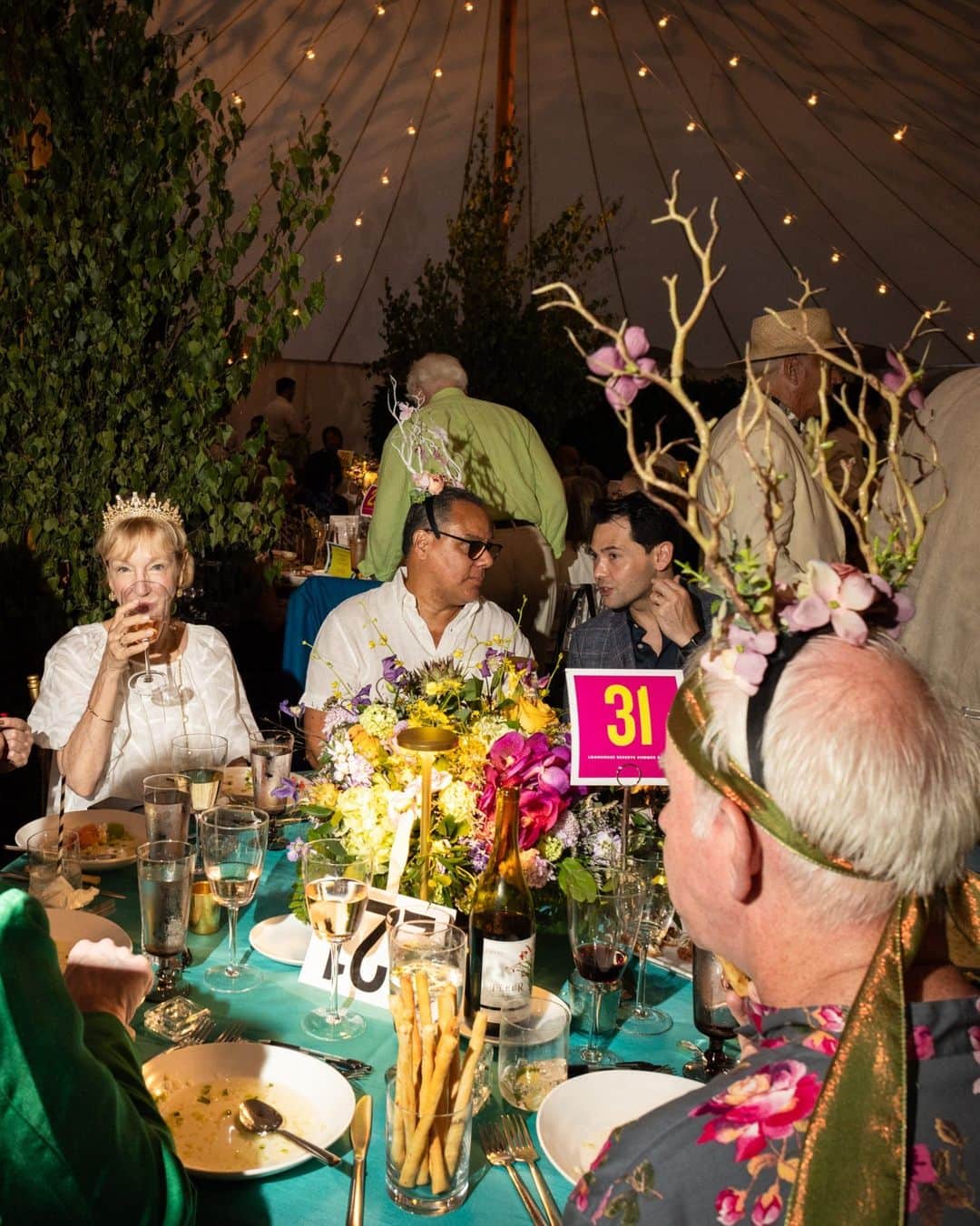 New York Times Fashionさんのインスタグラム写真 - (New York Times FashionInstagram)「At parties in the Hamptons this weekend, extravagance was a theme – especially when it came to attendees’ wardrobes.  “Go big or go home, right?” said Shani Grosz, who wore an immense straw hat to Polo Hamptons, an annual cocktail party and polo match on Saturday. The event drew a crowd of more than 900 people to the sprawling, private Fishel estate in Bridgehampton, New York. The model and actress Christie Brinkley sipped from a small bottle of rosé from Bellissima, her wine label, which people were also drinking nearby.  Later that evening, about 20 minutes away in East Hampton, young women playing flutes in long white dresses stood along a sandy path leading to a benefit at the LongHouse Reserve. (The theme was “Midsummer Dream.”) The event included a dinner, an auction and a dance party, and honored the artist Mary Heilmann and the author A.M. Homes. Attendees included Candace Bushnell, Cindy Sherman, Renee Cox, Bill T. Jones and Robert Wilson.  See more photos from the Hamptons social scene at the link in bio. Photos by @rebeccasmeyne」7月28日 0時02分 - nytstyle