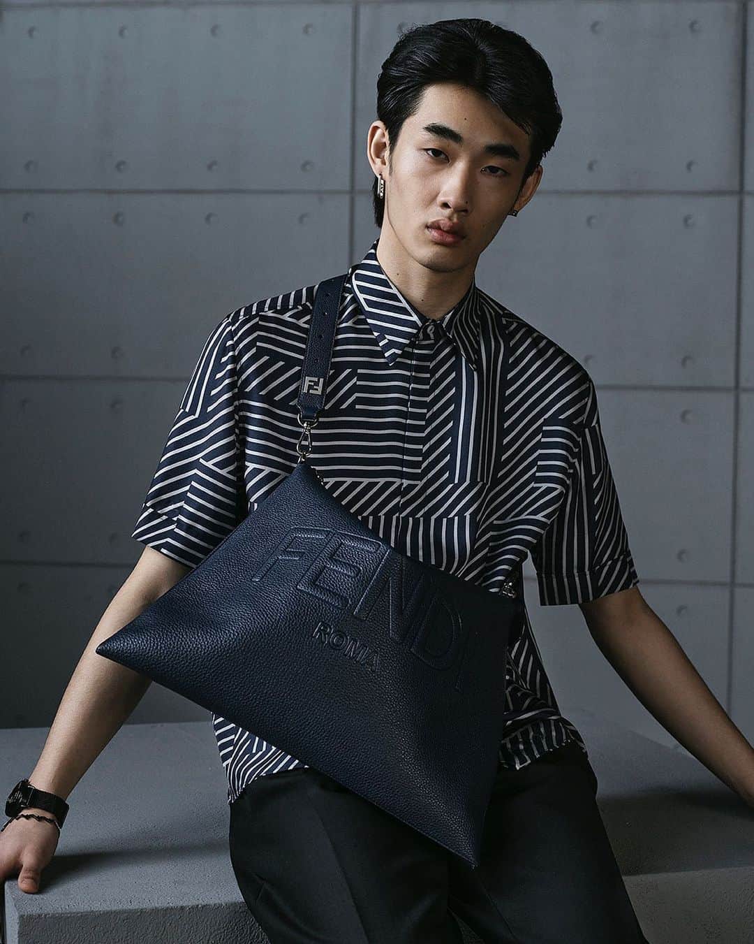 Fendiのインスタグラム：「New for #FendiFW23, the Fendi After bag is paired with a shirt featuring the new Fendi Shadow print, inspired by a heritage motif.  The bag comes with an extra long detachable shoulder strap adorned with an FF logo.  Artistic Director of Accessories and Menswear: @silviaventurinifendi ​ Artistic Director of Jewellery: @delfinadelettrez​  Photography: @brunostaub   Styling: @ganio Makeup: @samiamohsein Hair: @ramoneyluv  Casting: @piergiorgio  Model: Shaoqi Zeng」