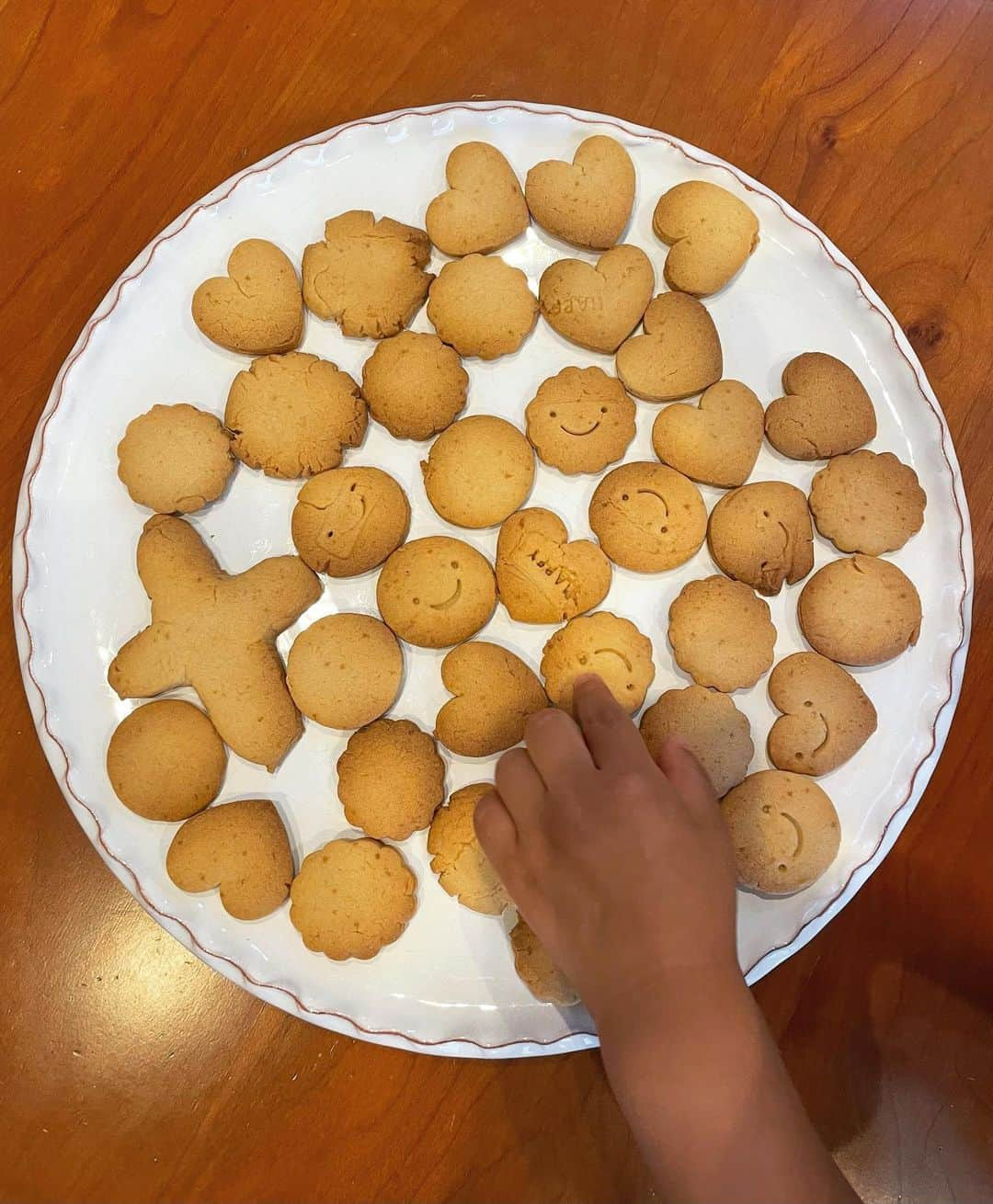 愛可のインスタグラム：「・ 息子くんとクッキーを焼きました。  なにしろ型抜きしている時から、 私の目を盗んでは食べそうになるから うかうかしていられない。  昔みたいに1人で丁寧にゆっくりと楽しみながら作る事はできませんが、焼き上がりの時の楽しさは何倍にもなった☺️  にしても、連日の水遊びで息子の手が黒い。」