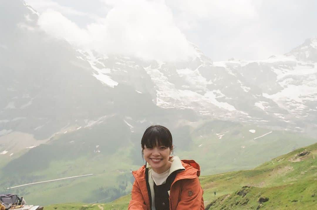 岸井ゆきののインスタグラム：「BS4K『体感！夏のスイスアルプス』が今夜7:30〜放送されます⛰️🇨🇭🌼 第一回目の今日はアルプスの大自然や伝統的な暮らしに触れる旅です。 アルプスでハイキング🥾 牛は歩くたびカウベルを鳴らして、自由で、人懐こくて可愛くて、生きているにおいにあふれていて、それぞれのいのちといっしょに生きている、美しくてたくましい生活の景色でした！ さっき搾乳されたミルクでチーズを作る工程をお手伝いして、そのあと雲の上のお花畑で今ここでしか見られない花々を観察しました。 岩壁に咲く花はエネルギーに溢れ紫外線の関係で色がとても鮮やかです。 ガイドをしてくださったやなるさんと、あれはなに？どうして？これは？をくりかえして何度も立ち止まりました。ありがとうございます。 来週の第二回はアレッチ氷河を観に、登山鉄道でユングラウヨッホへ向かいます。 ひとまず今夜の放送をお楽しみに！」