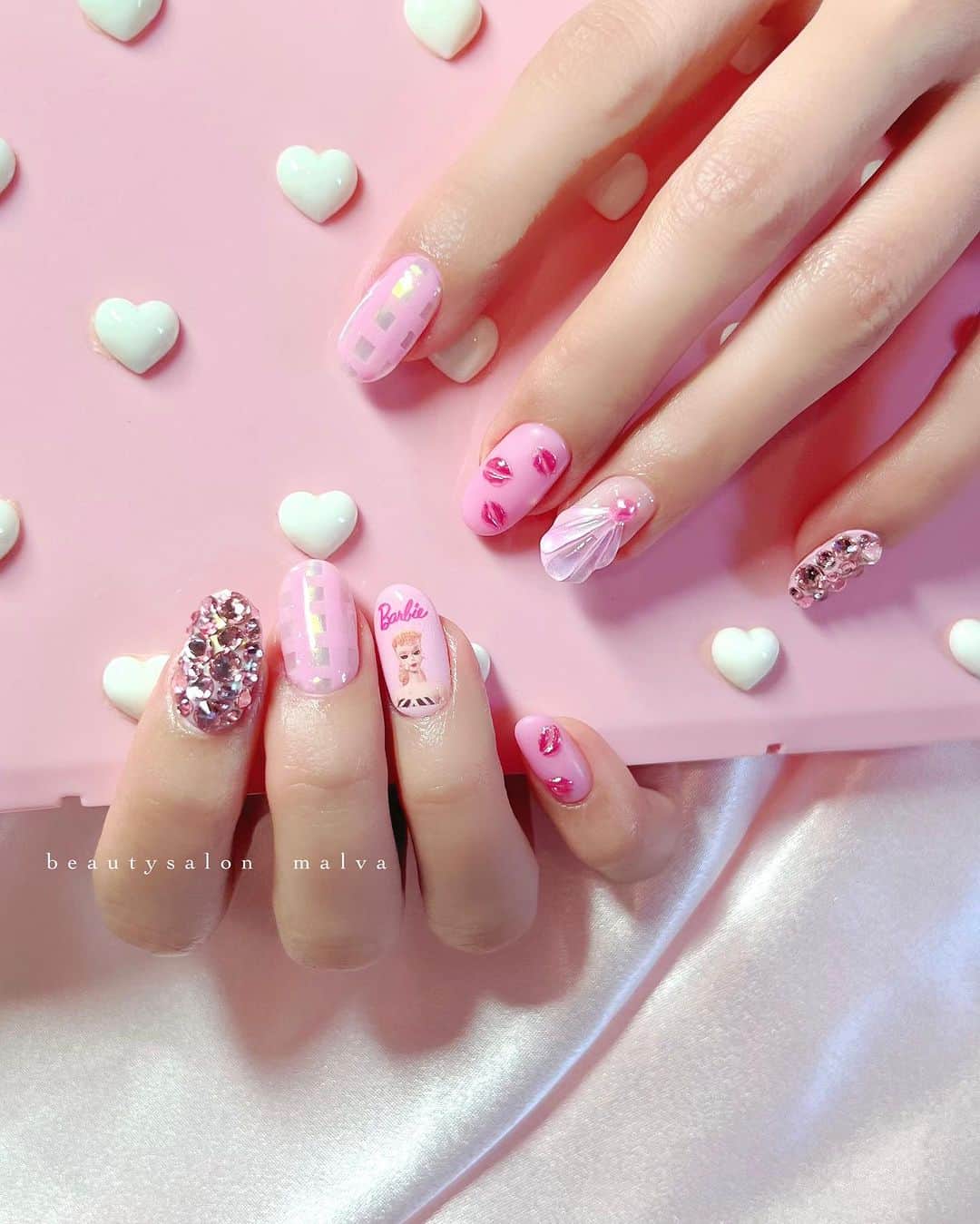 nailsalon malva（ネイルサロンマルヴァ）のインスタグラム：「スタッフ🆕ネイル💅 8月11日から公開の映画「バービー」@barbiemovie_jp @barbiethemovie の イメージに合わせたネイルです🩷 ⁡ ギンガムチェック、💋のアートに合わせて キラキラストーンの埋め尽くしや、 夏っぽいシェルアートも入ってます✨ ⁡ やりたい方はスクショしていただき サロンの公式LINEまでご連絡ください😊 ⁡ ⁡ ⁡ ※バービーのシールは正規のコラボ製品を使用しておりますので著作権を侵害せずネイルアートを楽しめます😌 ⁡ ＿＿＿＿＿＿＿＿＿＿＿＿＿ ⁡ ⁡ 𝐛𝐞𝐚𝐮𝐭𝐲𝐬𝐚𝐥𝐨𝐧 𝐦𝐚𝐥𝐯𝐚⠀ 📍明治神宮前駅｜原宿駅　徒歩𝟑分 ⠀ 💬ご予約やお問い合わせ 𝐋𝐈𝐍𝐄から承っております @ 𝐦𝐚𝐥𝐯𝐚 ⁡ お気軽にご連絡ください♡ ⁡ ⁡ ＿＿＿＿＿＿＿＿＿＿＿＿＿＿ ⁡ ▸ジェルネイル｜スカルプ｜ケア ▸まつげカール｜まつげエクステ ▸ハーブよもぎ蒸し ▸ワックス脱毛 ⁡ ⁡ \ アシスタント募集中💁‍♀️ / ⁡ ▸リモート可オンラインの画像動画制作アシスタント ▸サロンワーク全般アシスタント ⁡ ⁡ ⁡ ⁡ ⁡ ⁡ #nobarbenheimer #バービーネイル #barbienails #映画バービー #malva #malvaネイル #barbiethemovie #バービー #ネイルデザイン #ピンクネイル  #ネイル #原宿ネイル #シェルネイル  #表参道ネイル #東京ネイルサロン　#明治神宮前ネイル #新宿ネイル #千駄ヶ谷ネイル  #harajukunails #tokyonails #tokyonailsalon ⁡」