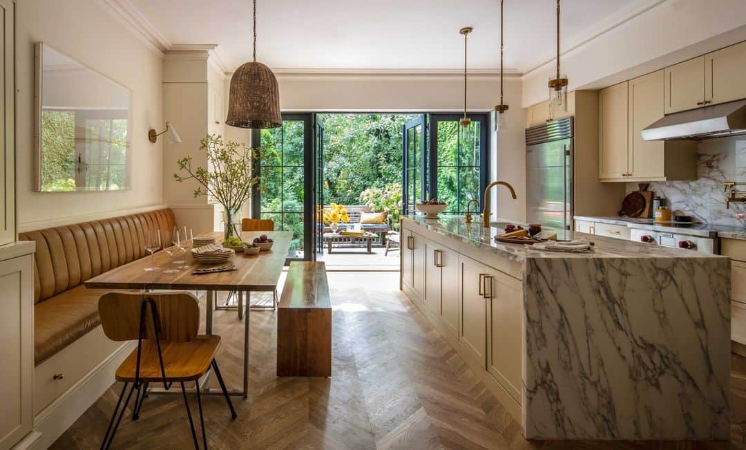 ELLE DECORさんのインスタグラム写真 - (ELLE DECORInstagram)「In the neutral-toned kitchen of this effortless Brooklyn home, it’s possible to feel transported to the English countryside. In fact, that’s what designer Georgia Tapert Howe (@georgiataperthowe) aimed to do for her British clients. “We didn’t want anything to feel too perfect and too matchy-matchy,” Howe says. “English design works in this kind of beautiful way that doesn’t feel too manicured." Here, the banquette is covered in @jerrypair leather, and the bench is by @fromthesource. The sconce and island pendants are by @visualcomfort, and the cabinets are painted in Matchstick by @farrowandball.   Click the link in bio to tour the rest of this Brooklyn brownstone. Written by @bebehoworth. Photographed by @christopherstark.」7月30日 7時00分 - elledecor