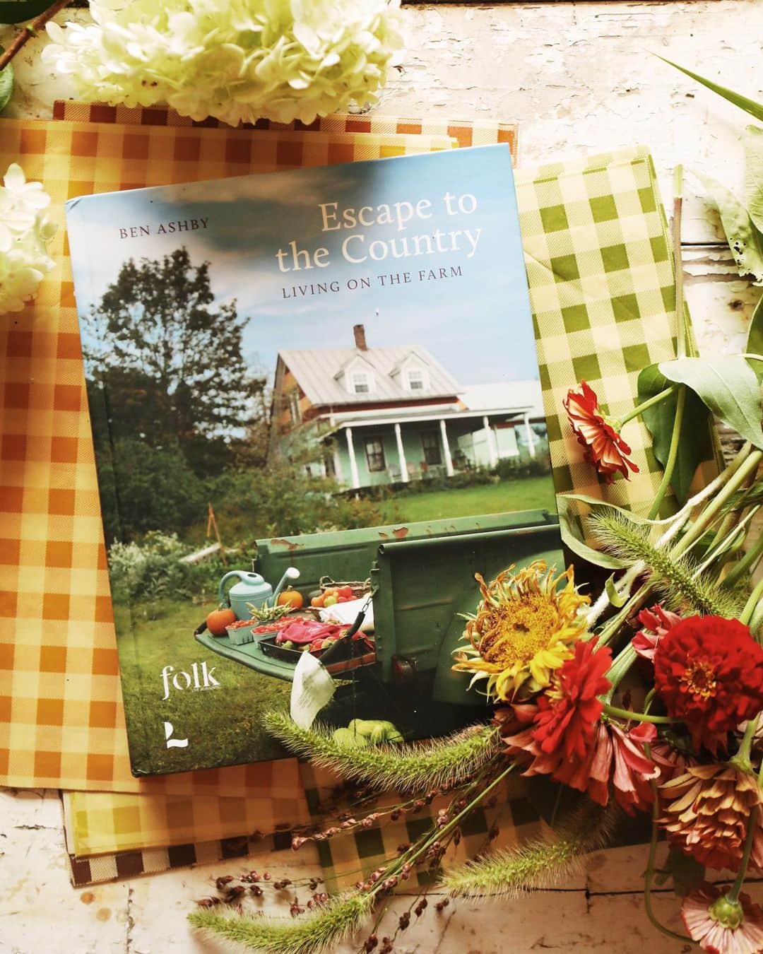 FOLKのインスタグラム：「🍎ESCAPE TO THE COUNTRY — LIVING ON THE FARM  a hardcover coffee table book by folk | now available   It was a passion project that took a year longer than expected. A journey from living in The City to moving back to western Kentucky and into a 120 year old farmhouse that was built by my great great grandparents. It had been a dream since I was four to one day own this place and to live a quiet life in the country....a bucolic valley in the middle of nowhere that my family first settled in the 1780s. This book follows that journey, but in the process it took on a life of its own.   This coffee table book, a long and labored dream comes out in the US in August, but a few advanced copies are available now via the website. They're packaged and ready to ship, without delay. The 250 page book is a true beauty with the stories of 18 others from all across the country that have decided upon a rural life, a dozen recipes, and over 100 beautiful and timeless photos of rural life and rural homes at their best.   Welcome yourself into a world that feels cozy and warm, like a meal or a visit with a long loved neighbor. This book is a piece you will want to revisit over and over again, and for me it is truly a dream come true.   The book, its stories, its photos, and the energy that flows through it represents a shift here at FOLK. The online shop has closed, the final orders are in the process of going out, and a return to story telling has arrived. We ask to you order a copy of this book, because we know you will love it, and we already have it ready to send your way.」