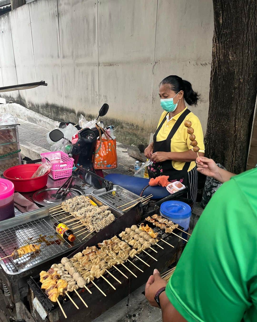 やまだひさしのインスタグラム：「孤独のグルメ 屋台の焼き鳥さん。 店員さんはエプロンの女性のみ。買いたければ自分で焼く。炭火でじっくり15分くらい、ひたすらひっくり返しながら待つ。そろそろか？と店員を見るとオッケーの様子。焼けた串の本数✖️10THB払って袋に入れて持ち帰る。 キュウリやキャベツはトッピング無料。 セミセルフおもろい。 #やまだひさし #ラジオ #DJ #グルメ #焼き鳥 #バンコク」