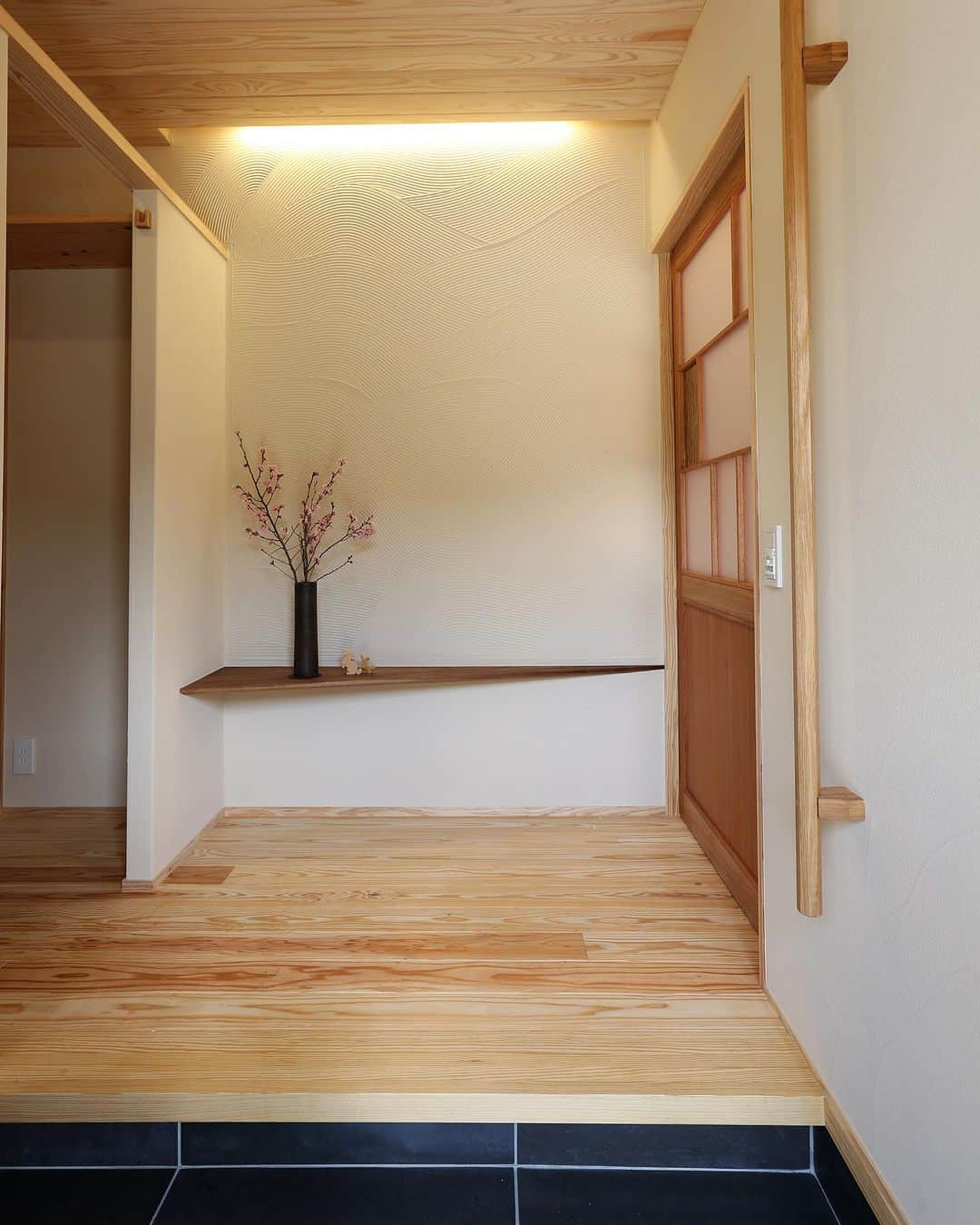 安成工務店さんのインスタグラム写真 - (安成工務店Instagram)「間接照明が空間を包み込む優しい玄関。飾り棚はウォールナットを使用しています。 玄関ドアには網戸も付いているため、夏場は玄関から風を通すことができます。  more photos…@yasunari_komuten  ...............  💡暮らしの中の“ちょっといいな”を集めました @yasunari_life  💡安成工務店がご提案する家具ショップ @ecoshop_com  ...............  #安成工務店 #yasunari #工務店 #注文住宅 #住宅 #木の家 #木造 #一戸建て #新築 #マイホーム #省エネ住宅 #エネルギー自給 #自然素材 #OMソーラー #家 #無垢材 #山口県 #福岡県 #季節を楽しむ #津江杉 #珪藻土 #セルロースファイバー断熱材 #輪掛乾燥材 #家造り #家づくり記録 #玄関 #玄関収納 #玄関飾り棚」8月1日 8時45分 - yasunari_komuten