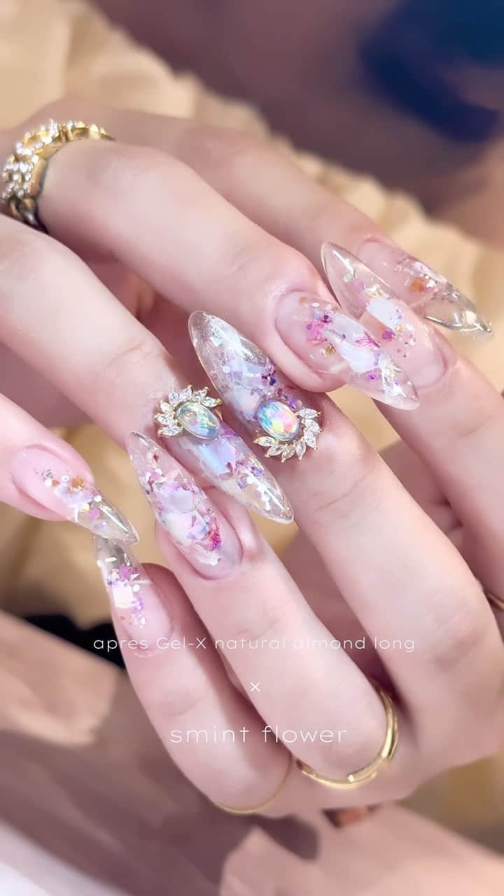 埜藤理恵のインスタグラム：「かわいすぎ🙄💓  apres Gel-X natural almond long この形と長さ最高よ。薄くて細くて大好き アプレ使ってるけどまだ持ってない方は是非getして♡ @apresnailjapan   薄パープルのシェルと smintの花びら菜-3に グリッターは IRORI by Renéeのfairylandシリーズgrapeを使用 @smint_product   このパーツも最近ハマってる〜！可愛いわ♡ 組み合わせが完全にモテ女子👼💓  このデザインは 8/29に開催される TSUKI.RIE.FUMIセミナーで 披露するデザインです🎵 受講予定の方は楽しみにしていてくださいね〜！！♡  □ Rie Nofujiプロデュース @tree01official エプロン 好評発売中  □ Renée professional brush シリーズ ＊オーバル ＊トップフレンチ ＊スマートフラット Renée web shop 全国ネイルディーラーにて発売中 プロフィールURLより飛べます  □ 店舗詳細 ⇩ 大阪府大阪市北区堂山町1-2 R&Eビル3階 am10:00〜pm20:00 JR大阪駅から徒歩7分 阪急梅田駅から徒歩7分 御堂筋梅田駅から徒歩7分  ご予約は サロンの公式LINEより受け付けております。 @rrieenee プロフィールURLより LINE飛べます。 LINEにて行き方動画も配信しておりますので ご参考くださいませ」