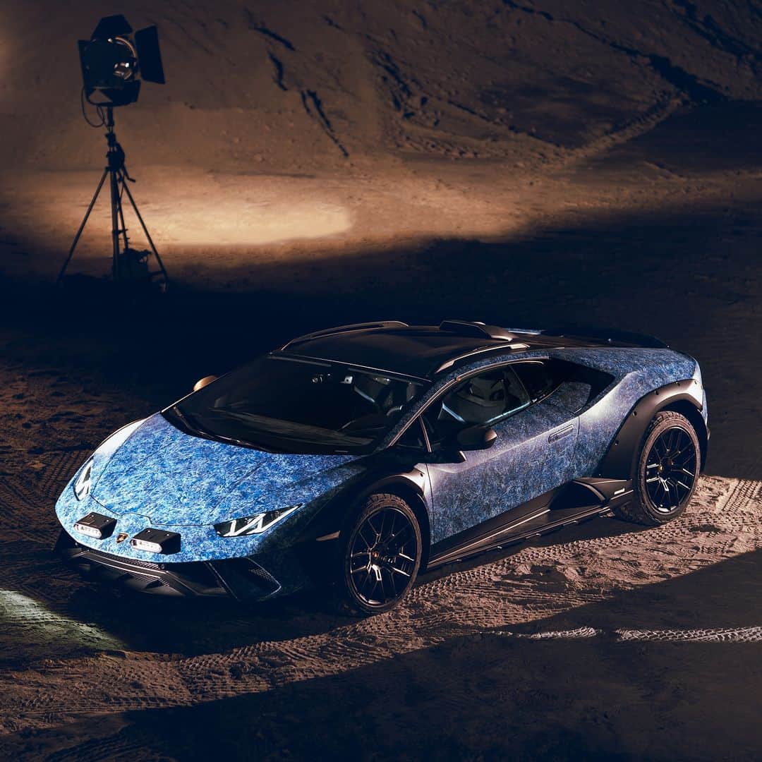 ランボルギーニのインスタグラム：「When it comes to going beyond, we are always eager to do so. This time, we ventured beyond the conventional with our Ad Personam department. Drawing inspiration from the captivating blue tones found in the seas and skies of Sardinia, we proudly present the extraordinary Huracán Sterrato 'Opera Unica.' This one-off piece of art was designed in a unique crystal-effect paint process to commemorate our 60th anniversary and celebrate the beauty of colors.  Huracán Sterrato 'Opera Unica' will be now showcased for visits by reservation at our Lounge in Porto Cervo until September 10th.  #Lamborghini #HuracanSterrato #BeyondTheConcrete __ Huracán Sterrato: fuel consumption combined: 14,9 l/100km (WLTP); CO2-emissions combined: 337 g/km (WLTP)」