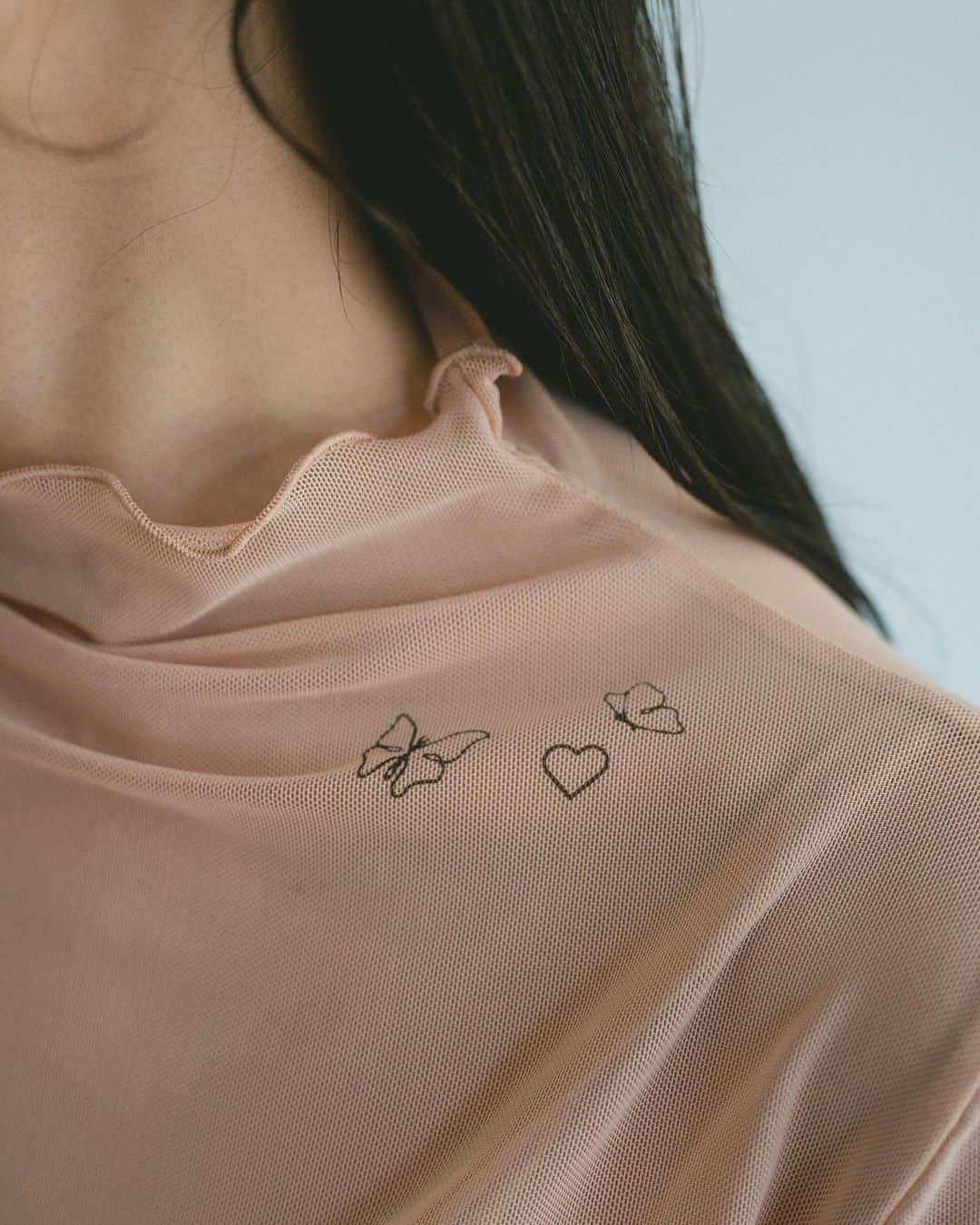 Vannie Officialのインスタグラム：「シアータトゥートップス  … Design …  ・4か所にタトゥープリントされたシアートップス ・ヌーディーカラーでさりげなくタトゥーを楽しめるデザイン ・背中：flower ・左腕：planet ・右手首：moon line ・鎖骨：heart butterfly  … Styling …  タトゥープリントがされたスキンTOPS。 秋冬もさり気ない肌見せをおしゃれに楽しむことができる一枚。 首、袖口はゆるやかなフリルメロウで1枚着も様になる仕様。  ━━━━━━━━━━━━━━━━━━━━━  透け感：あり 裏地：なし 厚さ：薄い 伸縮性：あり 光沢感：なし  ━━━━━━━━━━━━━━━━━━━━━━ ※詳しくは洗濯タグをご確認ください #vannie_u」
