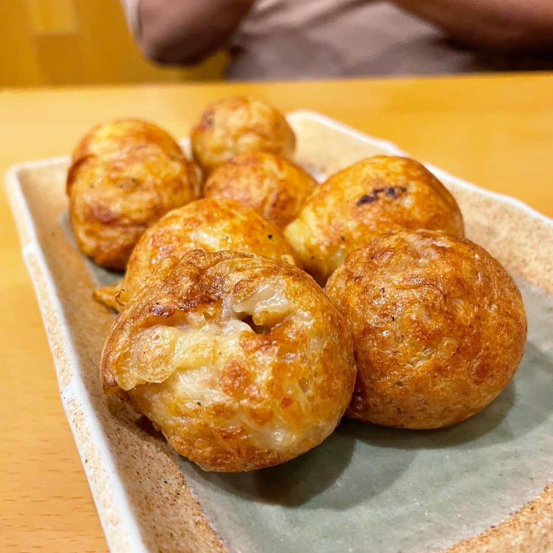 乾雅人のインスタグラム：「たこ焼き ふくよし@銀座 某日、放送作家 塩沢航先生と鮨を食べた後 「まさかこのまま帰るんじゃないでしょうね？」と先生。 たこ焼き食べながら飲み直すかと… 前置きはこれくらいにして 古い話で恐縮だが、大阪のレギュラー番組をやっていた20代後半、MCだった山城新伍さんがある日、たこ焼きを差し入れてくださった。 ソースがかかっておらず、生地の出汁だけの旨みで作られていた。 これがもう、とんでもなく美味しく…衝撃を受けた。 お店の名前を伺うこともなく山城さんがお亡くなりになった後も「あのたこ焼きをもう一度食べてみたい」とずっと思っていた。 で、かれこれ10年以上前になるが、大阪に行って「あの味を探してみよう」と思い立ち、3泊4日たこ焼きの店だけを巡るツアーを敢行。 当時、平和だったTwitterで「出汁の効いたソース無しの美味いたこ焼き屋」をたくさん教えていただきながら車で一軒一軒潰して探し回った。 しかし、出会うことは叶わず。 落胆して帰京すると「おそらく近い味のものが東京銀座にあります。」と教えていただいた。 ご主人(故人)に出汁の効いたたこ焼きを大阪まで探しに行った旨を話すと「出汁だけで勝負する店はもうあんまりありません」と。 そして焼き上がったこの店のたこ焼き「そのまんま」をいただくと 「あ、これだ」 以来、店内で、テイクアウトで立ち寄らせていただいている。 間違いなく東京で一番美味いたこ焼き屋です。 銀座店の斜向かいにはコロッケで有名なチョウシ屋さんもありますので昼呑みの帰りにコロッケを買って…なんてのもアリです。 赤坂にもお店があるのでご興味ある方はぜひ。」