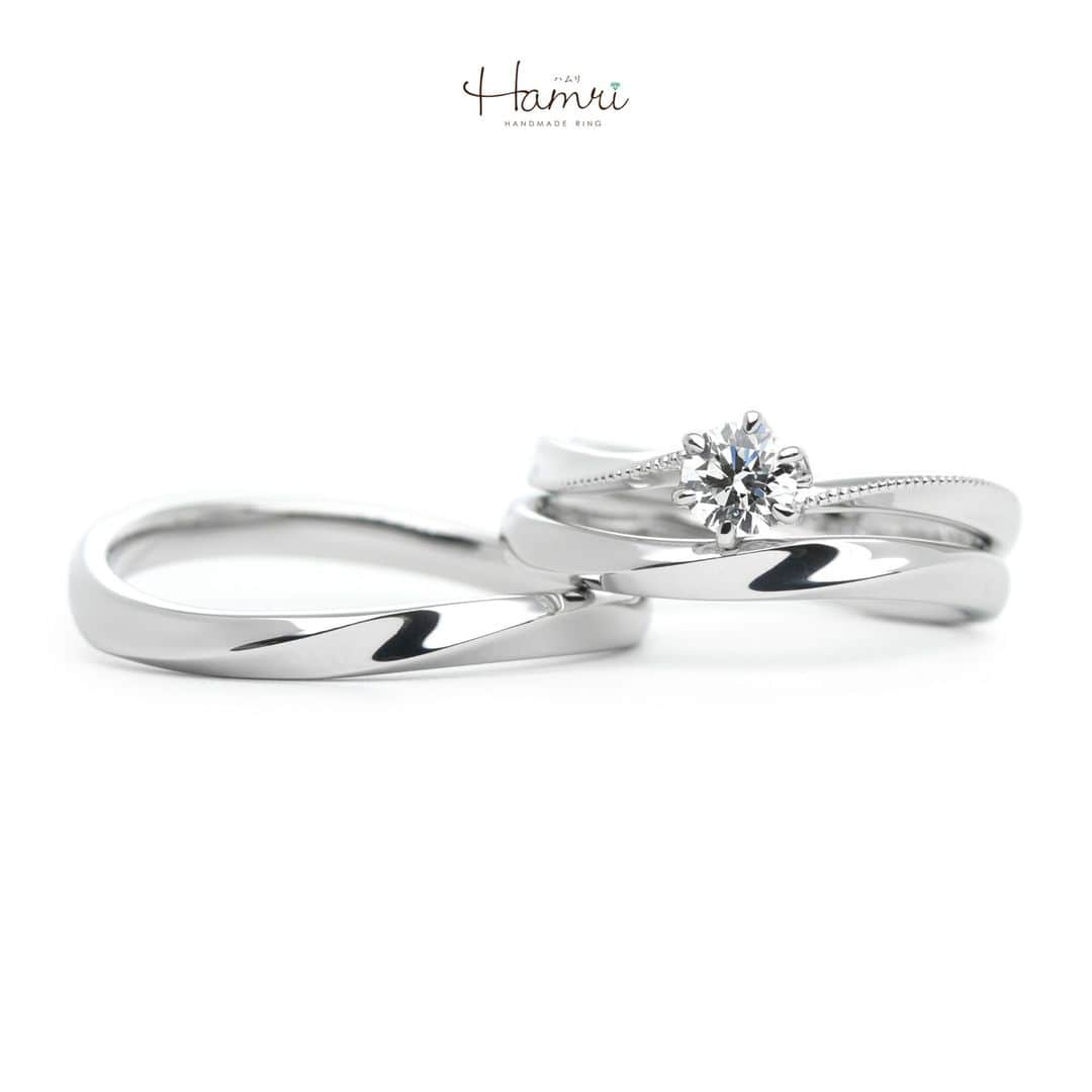 結婚指輪・婚約指輪『Hamri(ハムリ)』のインスタグラム：「【手作り結婚指輪・婚約指輪】  お手元を綺麗に見せてくれるウェーブのデザインをベースにお作りいただきました！  結婚指輪はお二人ともふたひねりのデザインで鏡面仕上げでシンプルな仕上がりとなっております。  それぞれに似合う幅感でお作りいただいているのもポイントです。    婚約指輪は、重ね付けも考えながらお作りいただいたデザインです。  サイドに伸びるミル打ちには千の粒という意味があり「永遠」を表しております。  内側にはお二人の記念日とお名前が刻印され お二人の想いが詰まった素敵な指輪が完成いたしました！  お二人の幸せが末長く続いていきますように。ご結婚おめでとうございます！  ==========================  ♦︎♢指輪制作の写真や動画を無料撮影、全データプレゼント♢♦︎  DMやLINEでのご相談お待ちしております♥ ⇒@hamri_omotesando  ❁・❁・❁・❁・❁・❁・❁・❁・❁・❁・❁  ＊結婚指輪・婚約指輪セットリング5%OFF＊  @hamri_omotesando  Hamri「ハムリ」  〒150-0001 東京都渋谷区神宮前5-11-11 2F  tel 0120-121-175 hp https://hamri.jp/  open 11:00〜19:00 close 火/水　祝日営業  ❁・❁・❁・❁・❁・❁・❁・❁・❁・❁・❁  #手作り結婚指輪 #手作り婚約指輪 #結婚指輪 #マリッジリング #エンゲージリング #プレ花嫁 #Hamri #Hamri表参道 #オーダーメイドリング #鋳造 #ブライダルリング #婚約指輪 #結婚指輪重ね付け #プラチナリング #婚約指輪重ね付け #ミルグレイン  #ダイヤモンド #コンビネーションリング #2023wedding #2023春婚 #2023夏婚 #プレ花嫁準備 #プレ花嫁と繋がりたい #結婚指輪探し #結婚指輪選び #結婚準備  《Hamri検索タグ》  #Hamriデザイン #Hamri指輪作り #Hamri花嫁」