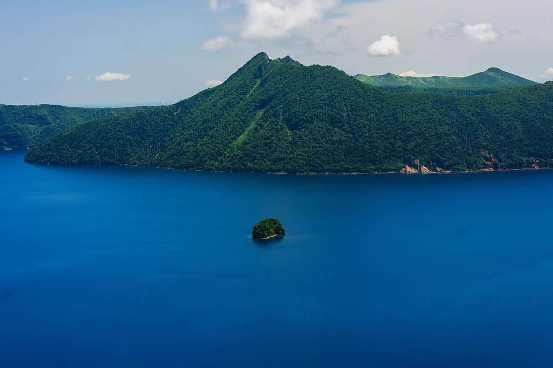 Michael Yamashitaのインスタグラム：「Hokkaido Blue:  1)Lake Mashu known for the unique color of the water dubbed “Mashu Blue”. Located in a caldera in Akan-Mashu National Park, the lake has an unchanging water level, due to the fact that no rivers flow into or out of the lake. Mashu Lake  has had an average visibility level of  20 meters, claiming the title for the clearest in the world.   2) Blue Pond: Shirogane Blue Pond was made  by accident, as the by-product of attempts to control mudslides. Aluminum from the soil seeping into the water scatters the sunlight causes the pond to look blue.  #lakemashu #mashu #mashunationalpark #bluepond #bluelake #shiroganebluepond」