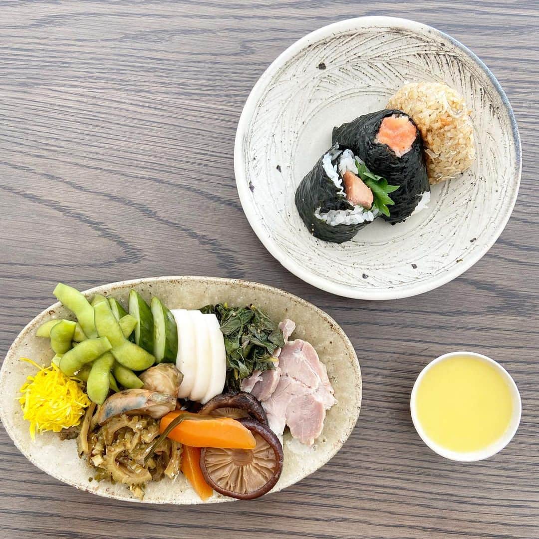 渡辺有子のインスタグラム：「個展中の作家さんとスタッフにまかないお昼ごはん。  おかず盛り盛りプレートに🌽冷製スープ。そして、母のおむすび。  母のおむすびがなにより大好きなもので…母がお店の近所ということもあり、つい甘えてお願いしちゃいます。ジャコとおかかの焼きおにぎり、明太子海苔おにぎり、スパムと青じそのおにぎらず⁈ 母、いつの間におにぎらずなんて覚えたのかしら。私はまだ作ったことないなぁ💦焼いたスパムと青じそが美味しかった〜。  おかずは豚肩ロースの麹蒸し、明日葉の梅あえ、小茄子の糠漬け、菊花の酢漬け、ゴーヤの黒酢黒糖炒め。母から、きゅうりとかぶの糠漬け、塩茹で枝豆、干し椎茸と人参の煮物、和梨。  元気が出て、またがんばれそう！」