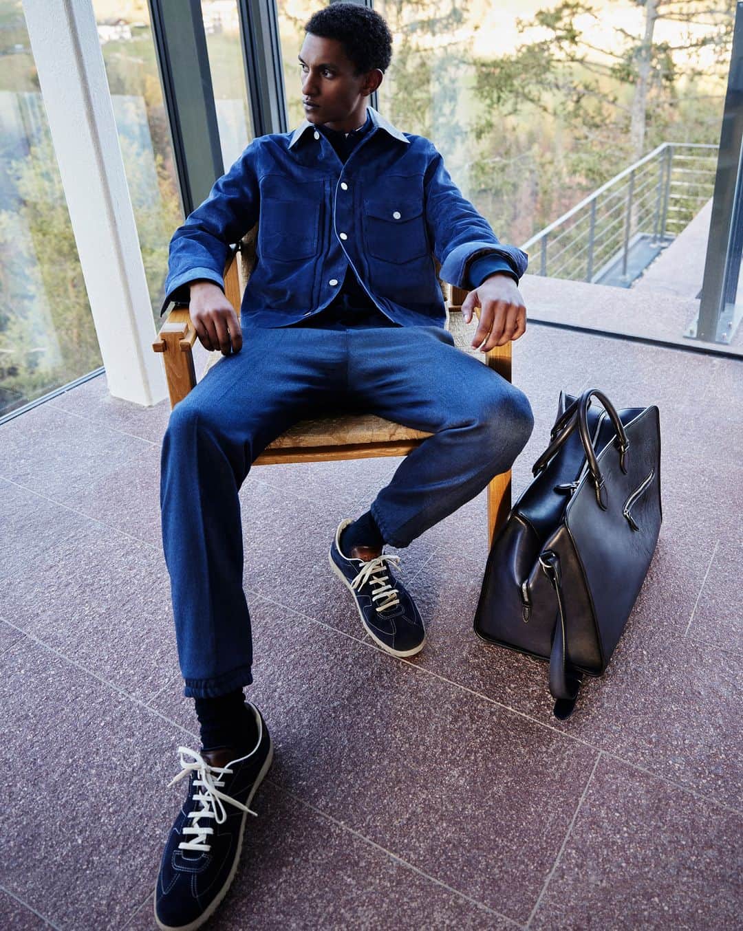 ベルルッティのインスタグラム：「- THE SILHOUETTE: FALL 2023 BY #BERLUTI -   Ease meets style as a monochrome denim look matches straight-leg jeans with a timeless jacket. Complete with the New Trainer in navy suede and an Overnight bag, it conjures an uncomplicated late Summer vibe.   Now available online and in-store.   Styling by @virginiebenarroch  Photography by @anthonyseklaoui   #BERLUTIFALL2023」