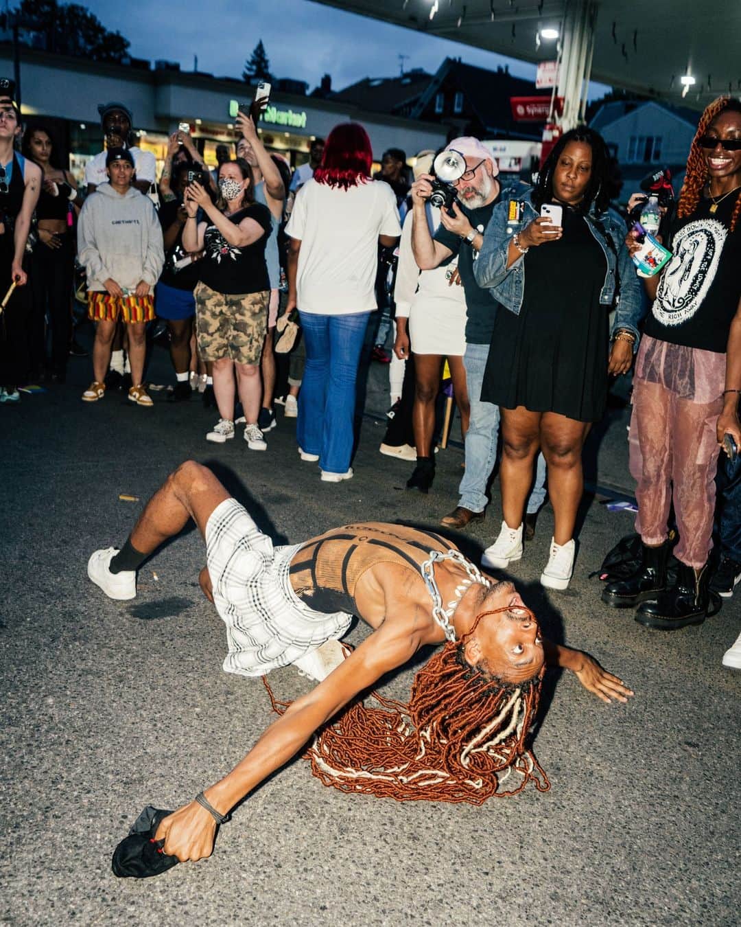 New York Times Fashionさんのインスタグラム写真 - (New York Times FashionInstagram)「Hundreds of mourners gathered on Friday at the Brooklyn gas station where O’Shae Sibley, a 28-year-old dancer and choreographer, was fatally stabbed last weekend after a dispute over his vogueing in the parking lot.  They chanted Sibley’s name while carrying Pride flags and posters that read “Vogueing is resistance.” At the foot of the gas station sign, some left shrines of lit candles, flowers and photographs of Sibley dancing.  As evening fell, LGBTQ activists and dancers took the megaphone to pay tribute to Sibley, who was gay and Black and whose murder has been charged as a hate crime.  In the moments before his death, Sibley and four friends stopped at the Mobil station on Coney Island Avenue after a day at the beach. They were vogueing to Beyoncé’s “Renaissance” album when they were confronted by a group of young men who told them to stop dancing and hurled gay and racist slurs. One of them pulled a knife and stabbed Sibley. His apparent attacker, a 17-year-old Brooklyn resident whose name has not been revealed, turned himself in to the authorities on Friday. He was charged with second-degree murder and criminal possession of a weapon.  Read more about the vigil for Sibley at the link in our bio. Photos by @poupayphoto」8月8日 1時11分 - nytstyle