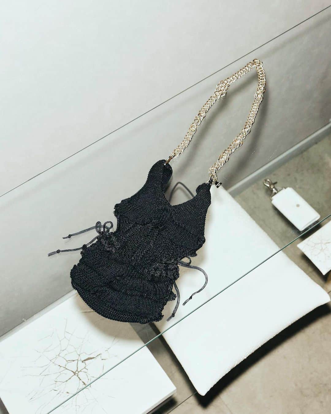 マラミュートのインスタグラム：「corset bag+ribbon 8月13日(日)まで @house_mikiri_lady にて期間限定で販売しております。  ODAKHAのアイコンであるビキニバッグが“オルタナティブコルセット”のテーマを取り入れたコルセットバッグという象徴的なアイテムに生まれ変わりました。 両サイドに透明のチューブヤーンで編んだハンドニットの装飾とリボンがあしらわれたエレガントなバッグに。 肩かけチェーンを取り外してスタイルによって使いわけできます。  カラー展開 ブラック、ホワイト  #odakha  #コルセット #bag #knit #ホールガーメント」