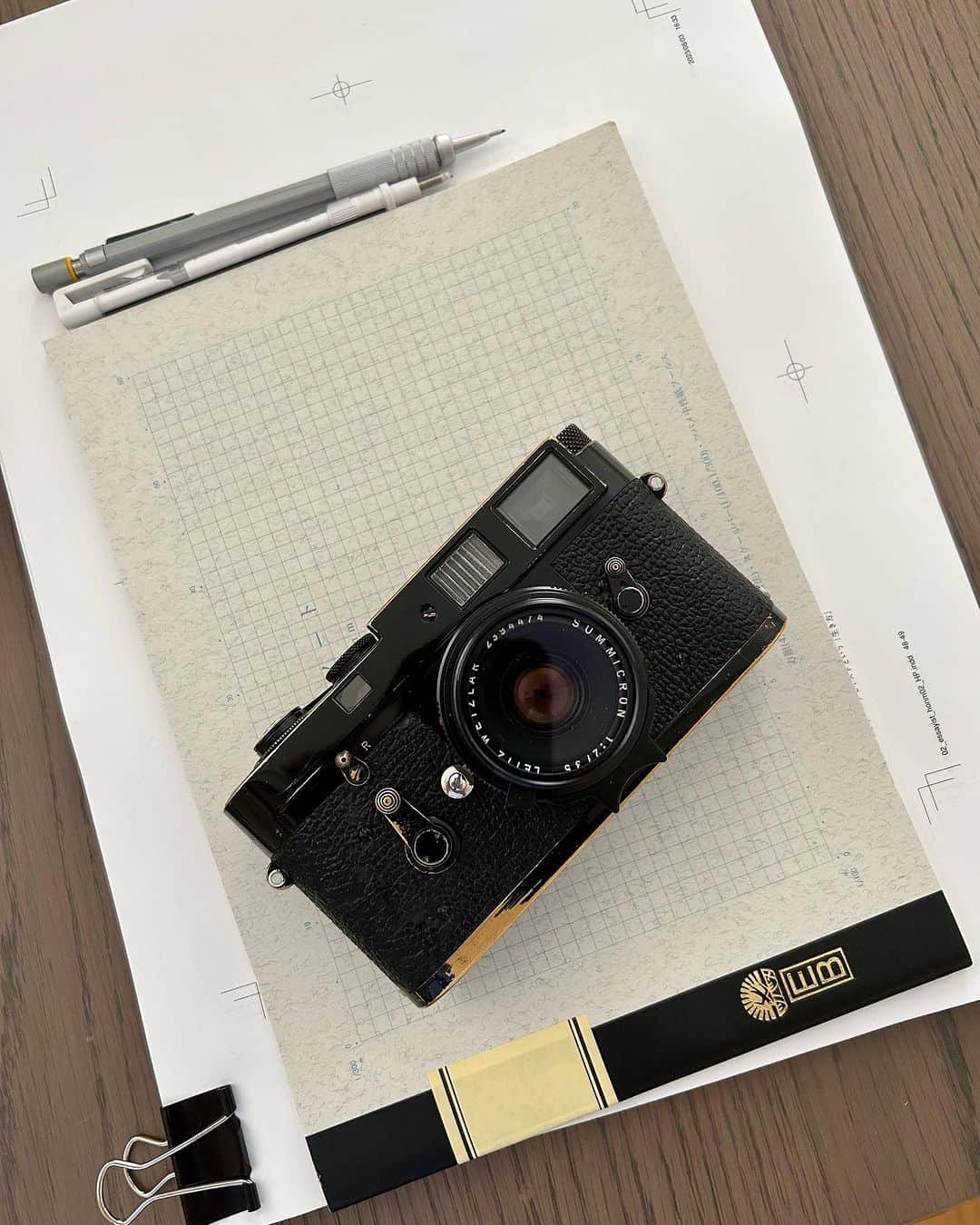 松浦弥太郎のインスタグラム：「机の上に、原稿のゲラとノート、シャープペンシル、そしてフィルムカメラ。なんだろう、ひと昔前の景色のようですが、ありのままの今日です、僕は時代に取り残されているかもしれない。#松浦弥太郎 #今日もていねいに #エッセイストという生き方」