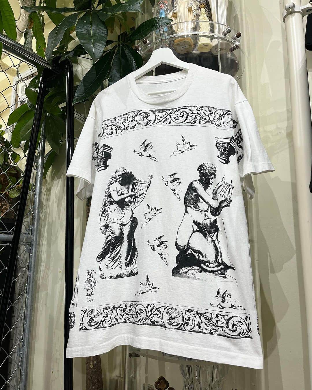 ジャムルのインスタグラム：「1990's～ All Over Print ¥13500+tax(14850) .  デカ版の神々しいプリントが目を引くカッコいいTシャツ。  竪琴を持っているところから察して恐らくギリシャ神話のゼウスの息子、アポロンか その息子のオルフェウス辺りのグラフィックだと思います。  前後両面に入るデカ版のグラフィックが秀逸で、神聖な雰囲気も抜群の1枚です！ . タグは欠損　袖、裾共にシングルステッチ。 背面の首元に薄らと小さなシミがございます。 全体的に多少の使用感はございますがコンディションは一般的なUSEDレベルだと思います。 .  WEB SHOPに入荷しております。 是非ご覧ください。 jammru.com  #お問い合わせはお電話で承ります #jammru#jammru_tee#vintagetshirt #vintagetee #osaka  #fashion  #streetstyle  #streetfashion  #vtg  #vintage  #used  #usedclothing  #古着 #古着屋 #ファッション #70s #80s #90s」
