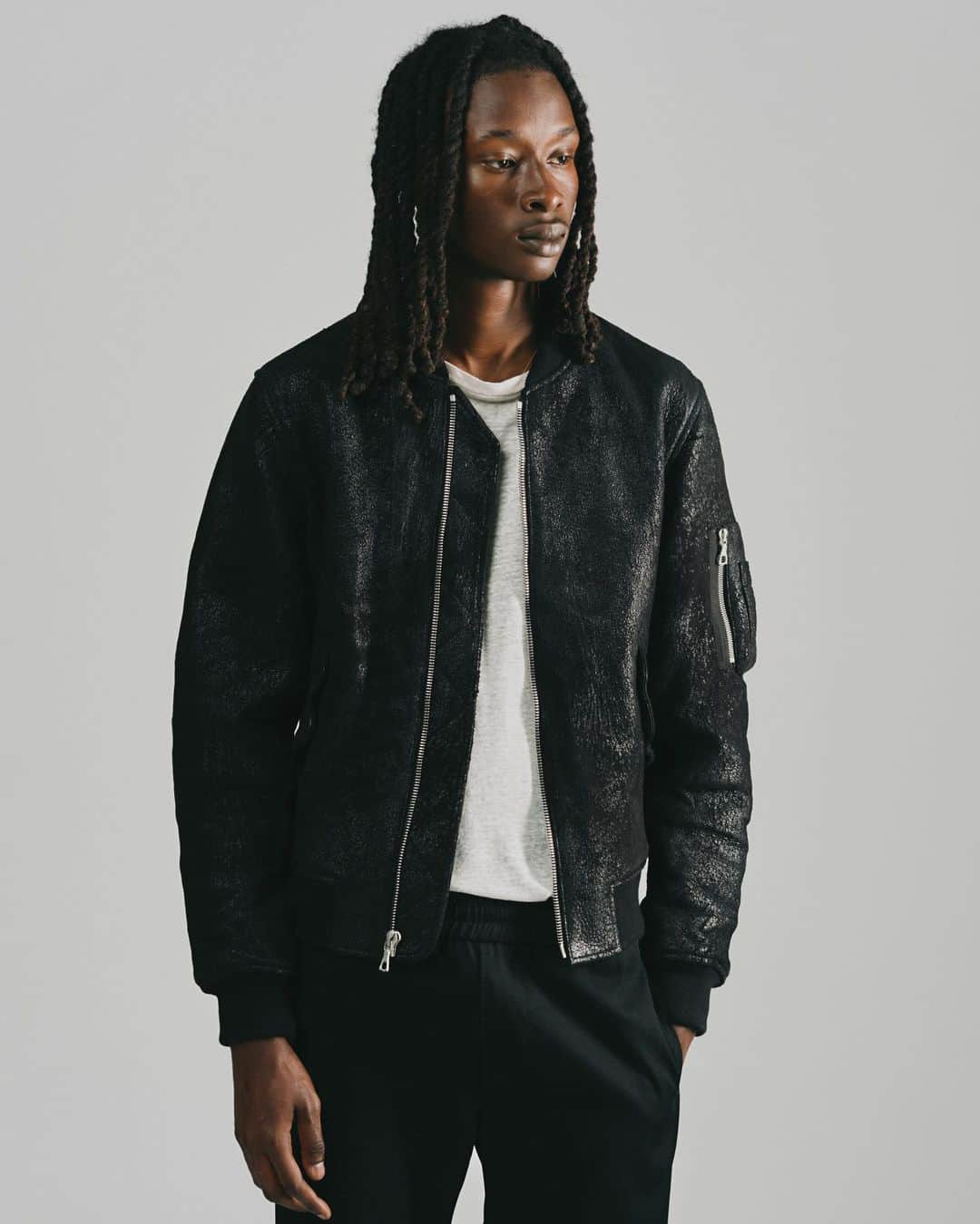 ジョン エリオットのインスタグラム：「Leather Bogota Bomber in Jungle Black. Tomorrow, 8.10.  Jungle leather is produced with European lamb. It’s hand-dyed, with each tone executed separately, resulting in unique variances. We use double-faced leather. The top is treated suede, and the back is Nappa. This strengthens the garment’s durability and allows for extra comfortable wear.」