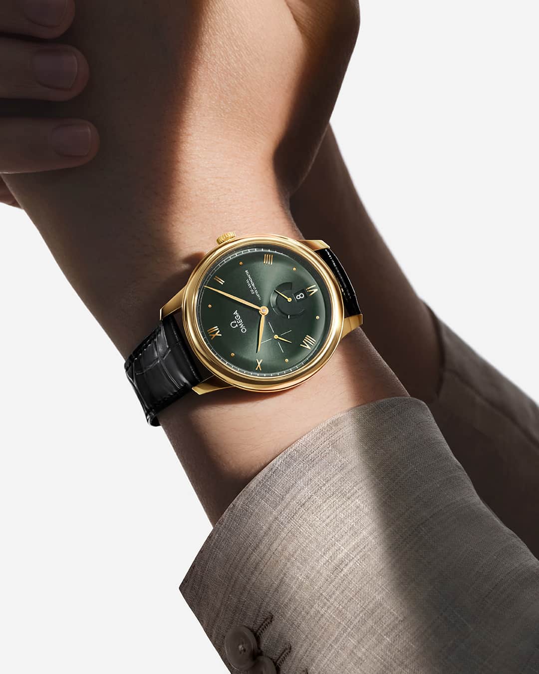 のインスタグラム：「Timeless embrace. OMEGA’s 41 mm De Ville Prestige in 18K yellow gold with sun-brushed dark green dial offers a warm touch.  #OMEGA #OMEGADeVille」