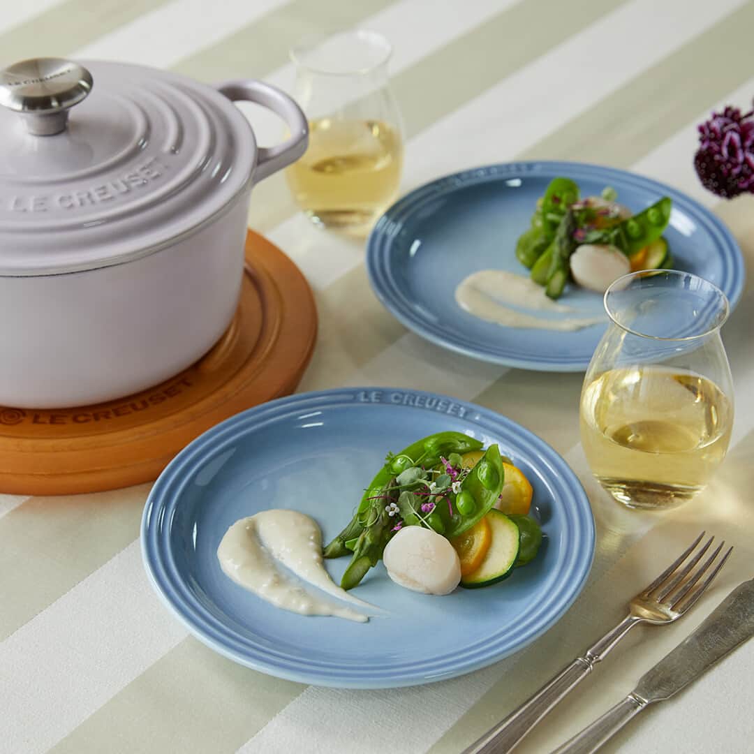 Le Creuset Japon　ル・クルーゼ ジャポンさんのインスタグラム写真 - (Le Creuset Japon　ル・クルーゼ ジャポンInstagram)「【ル・クルーゼ 公式レシピ】ホタテと季節野菜のエチュベ~ブールブランソース  エチュベ（蒸し煮）することで食材のうまみを引き出します。野菜はその季節に手に入るものをお使いください。 冷たいバターを使いゆっくり溶かしながら混ぜることで、つやのある滑らかなソースに仕上がります。  ======材料====== (4~5人分/シグニチャー ココット・ロンド 18cm)  (A) ホタテ貝柱(刺身用)・・・120g そら豆(さやから外したもの)・・・50g スナップエンドウ・・・５本 ズッキーニ (緑)・・・1/4本 ズッキーニ (黄)・・・1/4本 アスパラガス・・・３本 水・・・50ml 塩・・・少々  塩・・・ひとつまみ   エシャロット(みじん切り)・・・10g 白ワイン・・・50ml 生クリーム・・・30ml バター・・・40g 塩、こしょう・・・適量 エディブルフラワー、ハーブ・・・適宜 (お好みで)  ======下準備====== ・ホタテは塩をまぶし10分ほどおき、表面をペーパーで軽く拭く。 ・そら豆は1分ほど塩茹でし、皮をむく。 ・ズッキーニはそれぞれ5mmの輪切りにする。 ・アスパラガスは根元の固い部分を切り落とし8等分の斜め切りにする。 ・バターは2cmほどの角切りにし冷蔵庫で冷やしておく。  ======作り方====== 1.　鍋に(A)を入れ、フタをして中火にかけ約5分蒸し煮にする。焦げないよう時々上下を返すように混ぜ合わせる。 2.　ホタテに火が通ったら一度火を止め、具材のみ取り出し汁は鍋に残す。 3.　2.の鍋にエシャロットと白ワインを入れ弱火にかけ5分ほど煮る。生クリームを加え極弱火にし、ホイッパーで鍋に触れないように優しくかき混ぜながらバターを3回に分けて加える。塩こしょうで味を調える。 4.　ホタテと野菜を皿に盛り、3.をかける。お好みでエディブルフラワーやハーブを飾る。  #ルクルーゼ #lecreuset #ルクルーゼのある暮らし  #ルクルーゼごはん #テーブルウェア #テーブルコーディネート #キッチンウェア #キッチングラム #ルクルーゼのある生活 #ルクルーゼのある食卓 #食卓 #食卓グラム #キッチンツール    #シグニチャーココットロンド #エチュべ #蒸し料理 #おうちカフェ #おうちごはん #おうちレストラン」8月10日 18時45分 - lecreusetjapon