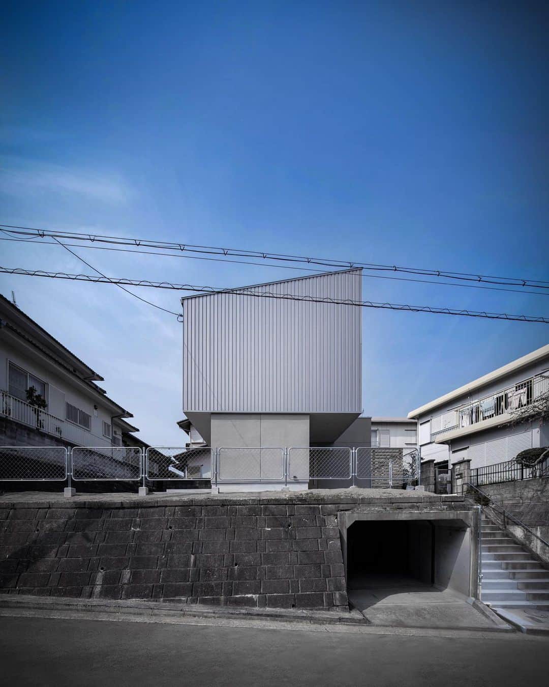 4E.okuwada architects officeのインスタグラム：「さかのさんのいえ  Sakanosan House Use: Residence Loc: Hyogo Okuwada Architects Office  雛壇上の敷地に建つ住宅です モルタルと金属の外観  #デザイン住宅 #こだわりの家 #かっこいい家 #おしゃれな家 #木造住宅 #モダン住宅 #デザイン住宅 #デザイナーズ住宅 #設計事務所 #設計士 #設計士とつくる家 #建築家 #建築家とつくる家 #モルタル #金属 (photo: Keishiro Yamada)」