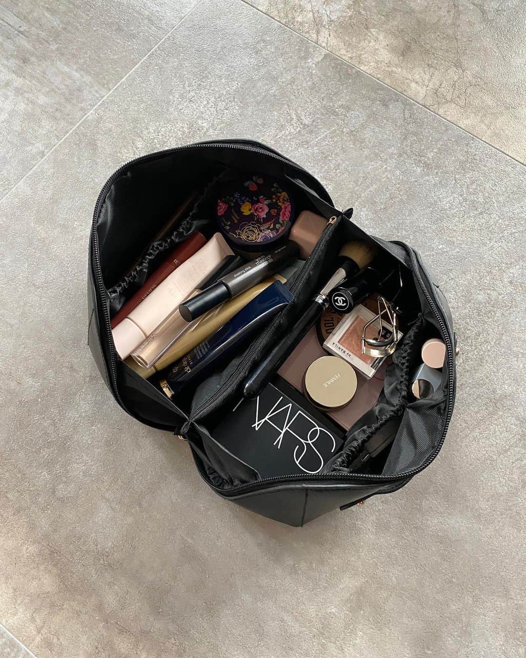 のインスタグラム：「Beauty 🤎  ポーチの中身。 このポーチ旅行用に買ったのだけど、 もっと早く買えばよかったってくらい優秀。 下地は日によって使い分けるので5本くらい入ってるけど それでもこの余裕素晴らしい✨✨  @cledepeaubeaute の下地はお値段張るけどかなり良い。 ファンデ要らないし、何より仕上がりが綺麗！  タイのお土産でリクエストした @srichand1948 は 日本みたいに湿度が高い地域だとかなりおすすめ。 こっち来てみたらびっくりするくらい乾燥してたので 今はアイブロウ部分のみ使ってます。  @colorgram.official はプチプラなのに 優秀アイテム多くて最近すきなブランド。 ハートのハイライトはイチオシ 🩷」