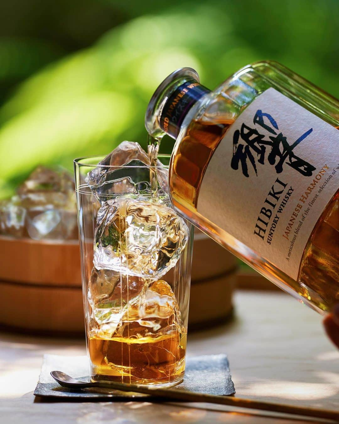 響 | SUNTORY WHISKY HIBIKIのインスタグラム：「. HIBIKI TIME ～二十四節気・立秋～  深緑に映える琥珀の煌めきに魅了され。 The amber whisky, brilliantly reflecting the rich green, enchants you.  #hibiki #響 #hibiki_time #二十四節気 #24seasons #立秋 #risshu #withnature #深緑 #木桶 #純氷 #切子グラス #kirikoglass #夏 #summer #夏の光 #summer #sunlight」