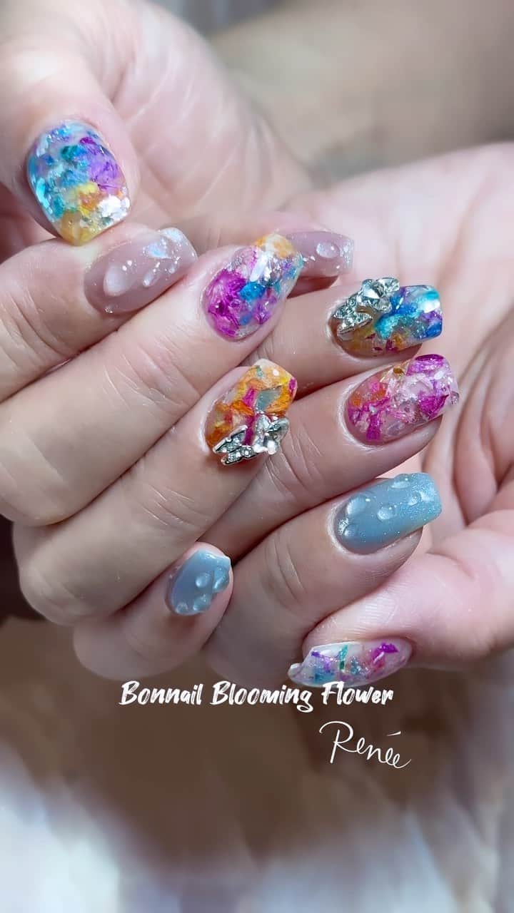 埜藤理恵のインスタグラム：「new item⭐︎ @bonnail_insta  Blooming Flower ピンクシャワー ブルーシャワー フラミンゴシャワー マンゴーシャワー の4色をMIX♡  お花だけじゃなく少しパラパラっと 大きめグリッターをon🎵  □ Rie Nofujiプロデュース @tree01official エプロン 好評発売中  □ Renée professional brush シリーズ ＊オーバル ＊トップフレンチ ＊スマートフラット Renée web shop 全国ネイルディーラーにて発売中 プロフィールURLより飛べます  □ 店舗詳細 ⇩ 大阪府大阪市北区堂山町1-2 R&Eビル3階 am10:00〜pm20:00 JR大阪駅から徒歩7分 阪急梅田駅から徒歩7分 御堂筋梅田駅から徒歩7分  ご予約は サロンの公式LINEより受け付けております。 @rrieenee プロフィールURLより LINE飛べます。 LINEにて行き方動画も配信しておりますので ご参考くださいませ」