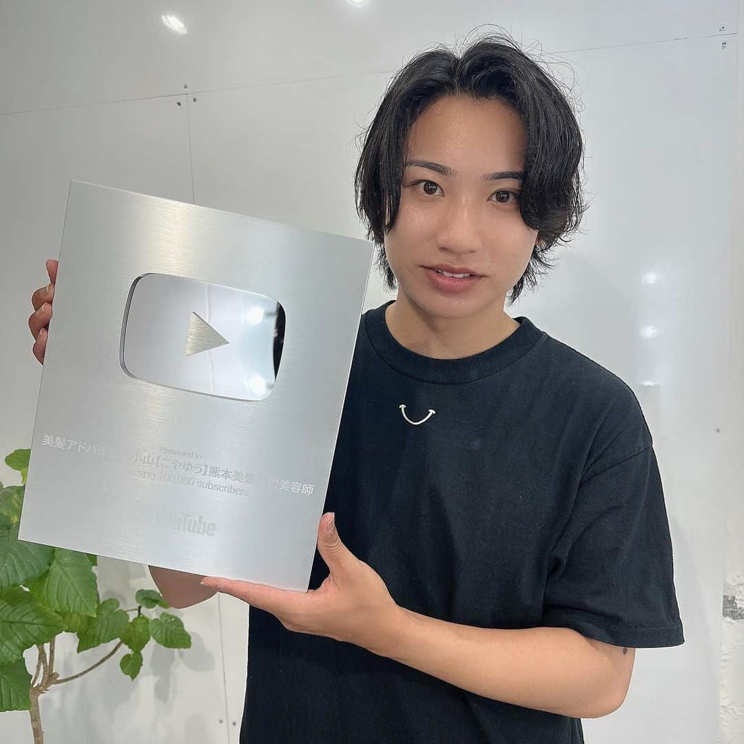 小山雄也のインスタグラム：「皆様のおかげで遂にYouTubeから銀の盾が届きました㊗️ ・ 小山は2枚目の写真のように笑顔になりました🙀 ・ そもそも 僕が美容師兼インフルエンサーとして活動を始めた 1番の目的としては ・来たくても遠くて熊本のお店に来れない人も多いので その方々に向けて少しでも自宅などで髪の毛を綺麗にできる情報を発信したいと思ったから。 ・ だから熊本から2年半くらいヘアケアメインで更新＋ライブ配信をしてきました。 そしたらいつの間にか 全SNS合計でフォロワー60万人超えてました😭 美容師インフルエンサーとしてトップになるのが僕の目標の一つでもあるのでまだまだだけど凄く嬉しい☺️ ・ 実は皆さんの日頃のコメントって 僕は全部読んでて 小山のモチベーションアップに繋がるんですよね。 これからもインスタやTikTokやYouTubeで沢山紹介したり豆知識など配信していくので皆さん応援よろしくお願いします😁 ・ ・ 美容知識が少しでも皆さんのお役に立てたなら 僕はめちゃくちゃ嬉しいです✌️ ・ 次はYouTube登録者20万人目指します ・ 本当に皆さんマジ謝謝❗️❗️❗️ ・ 目指せ！美容師トップインフルエンサー😌 それでは明日も美髪に。 #美容師#美容師youtuber #熊本美容師#熊本美容室」