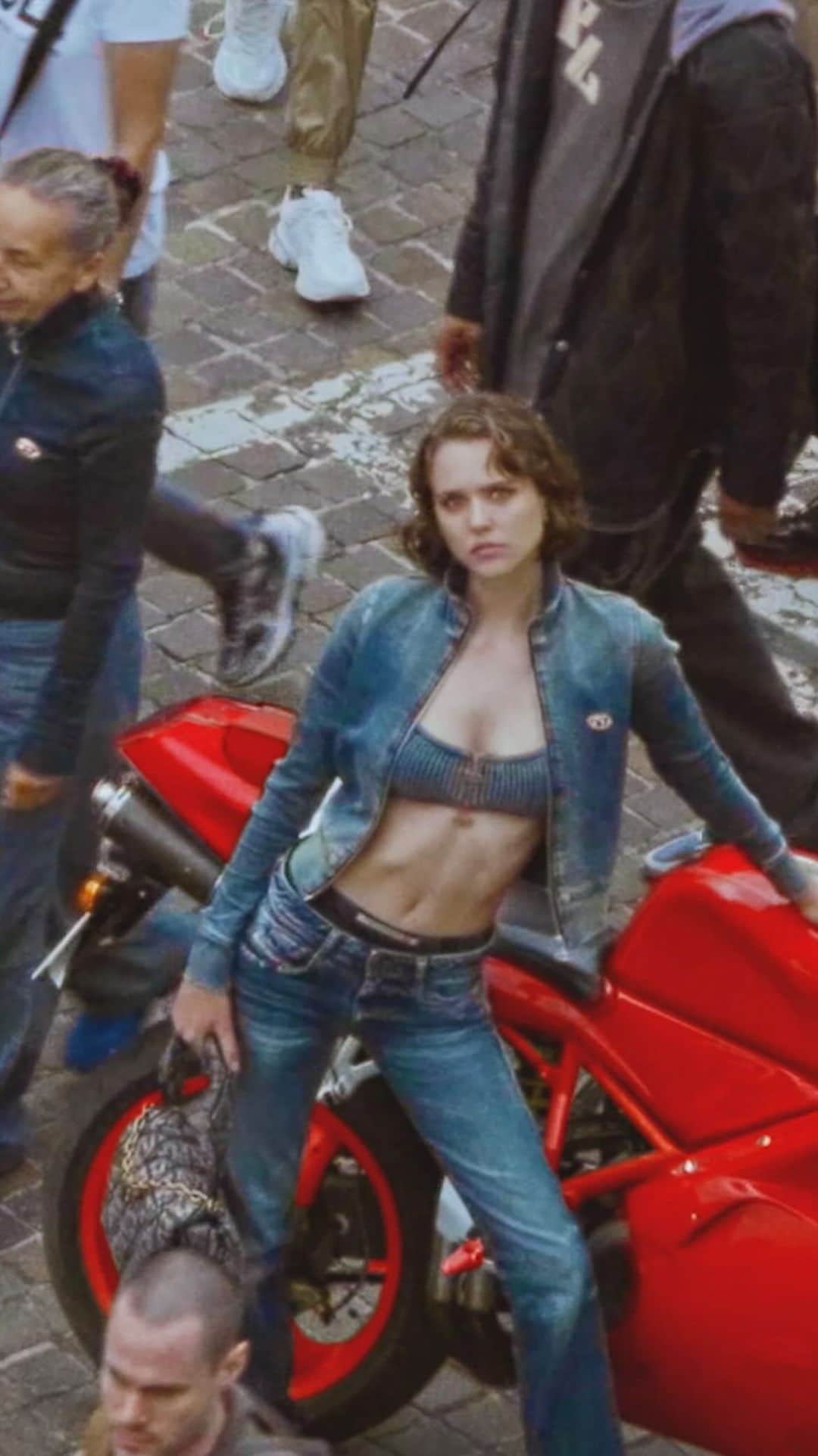 ディーゼルのインスタグラム：「Waving you into the land of D.    Drop in. Enjoy the scenery. Hot girl with a scooter. Sexy women washing cars. A cat fight over a bag. A primadonna singing from the parapet. She carried a watermelon.    They’re all members of Diesel’s fantastic female staff, modeling the #DieselFW23 for the “Find the D” campaign. Shot in Breganze, Italy, home of our headquarters, the shoot is an adults-only send-up of children’s puzzle books.    See more at the link in bio.   #ForSuccessfulLiving」